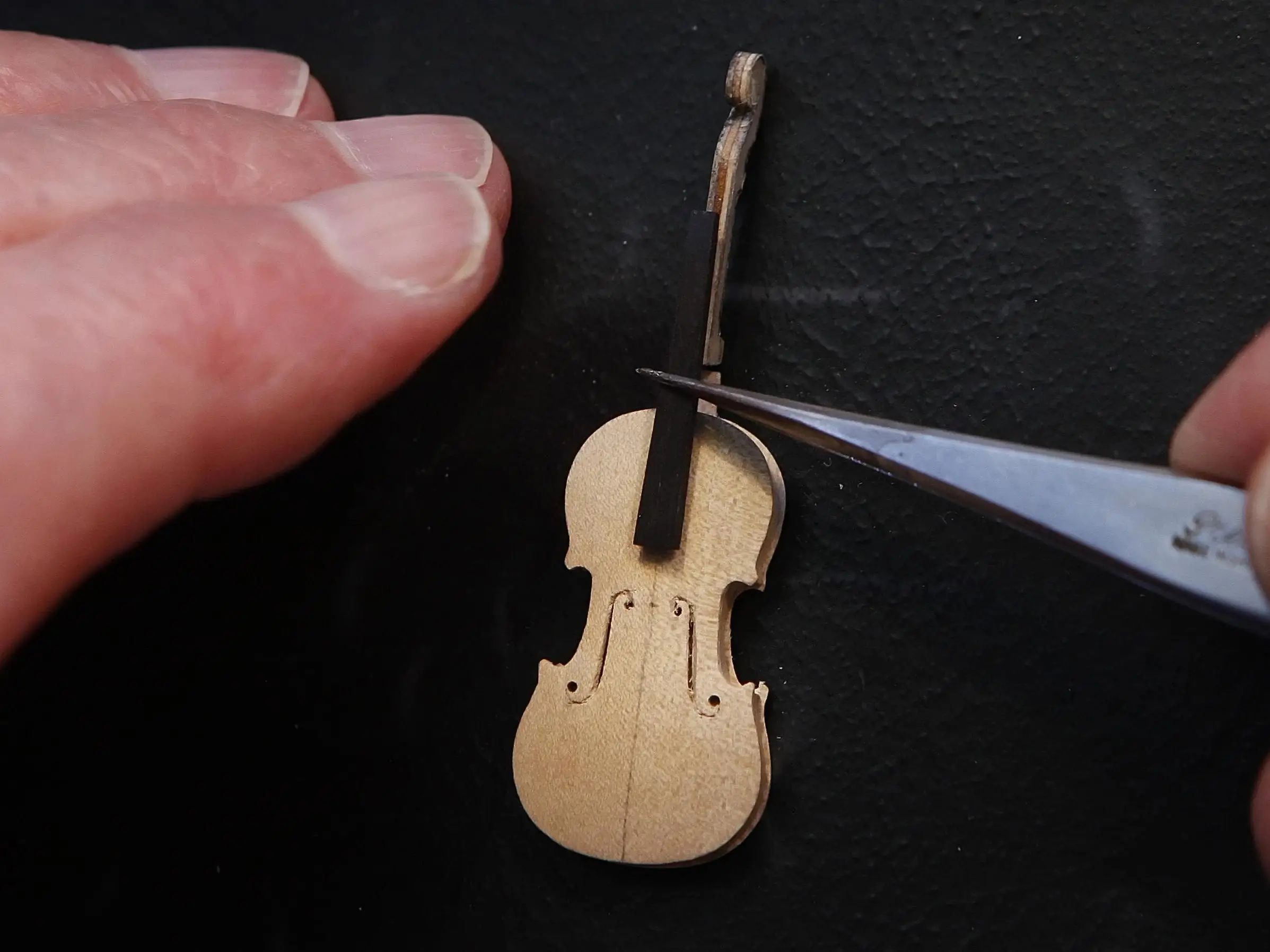 Former Royal Philharmonic Orchestra cellist David Edwards crafts a miniature Stradivarius violin, complete with sheep gut strings, in his Edinburgh workshop