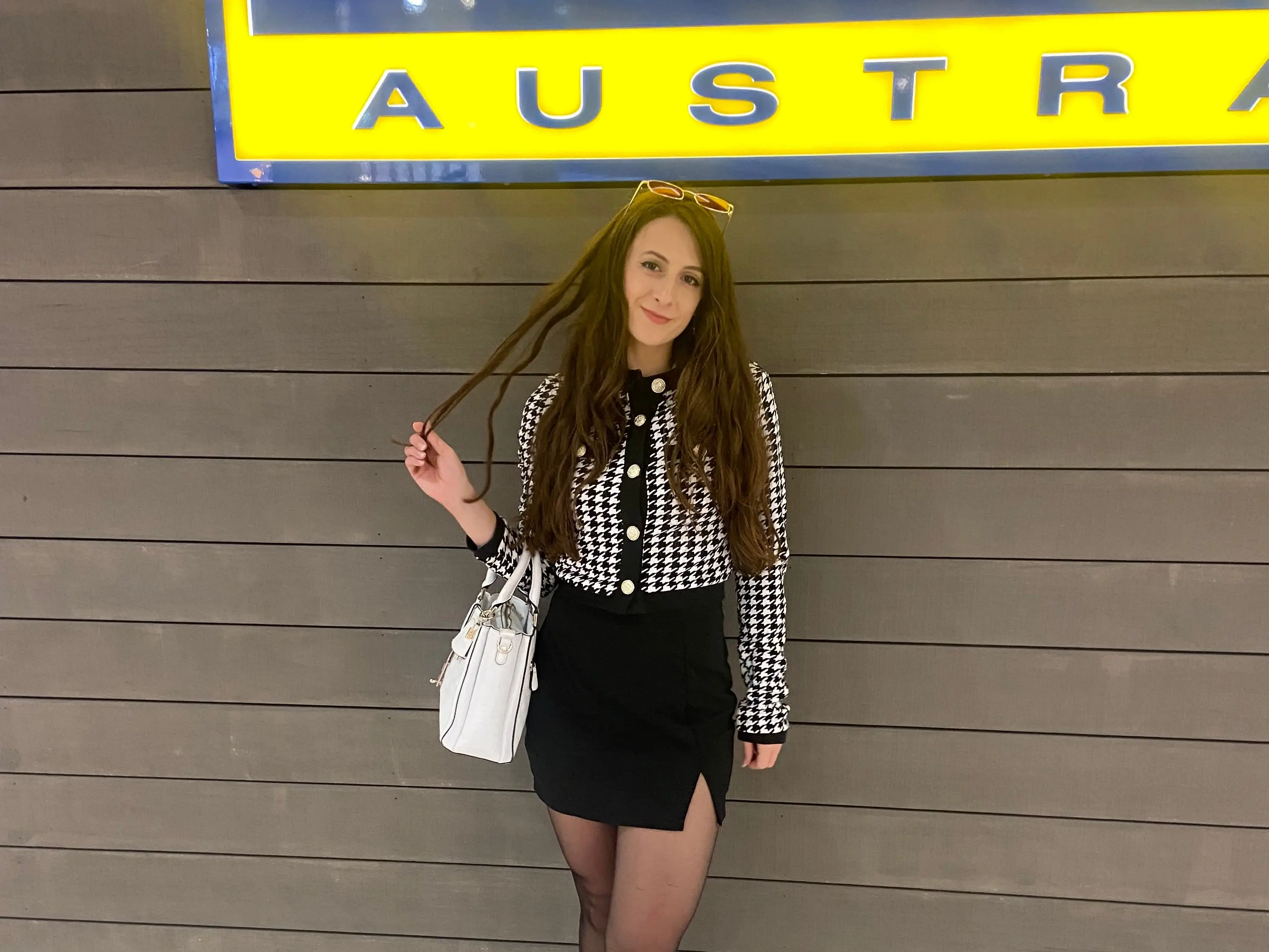 A woman stands in front of a sign that says 