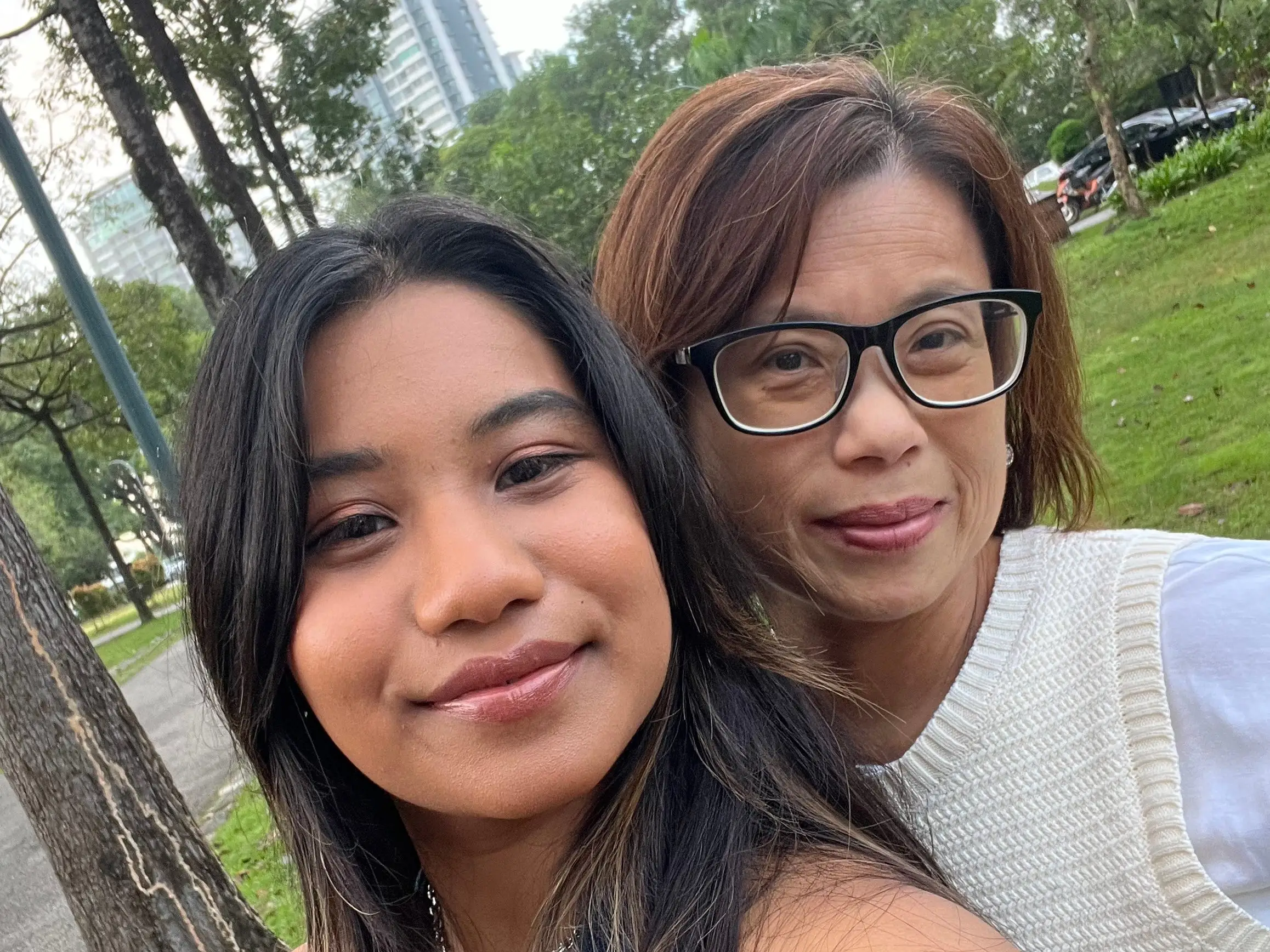 A selfie of the writer and her mom outside, with trees in the background.