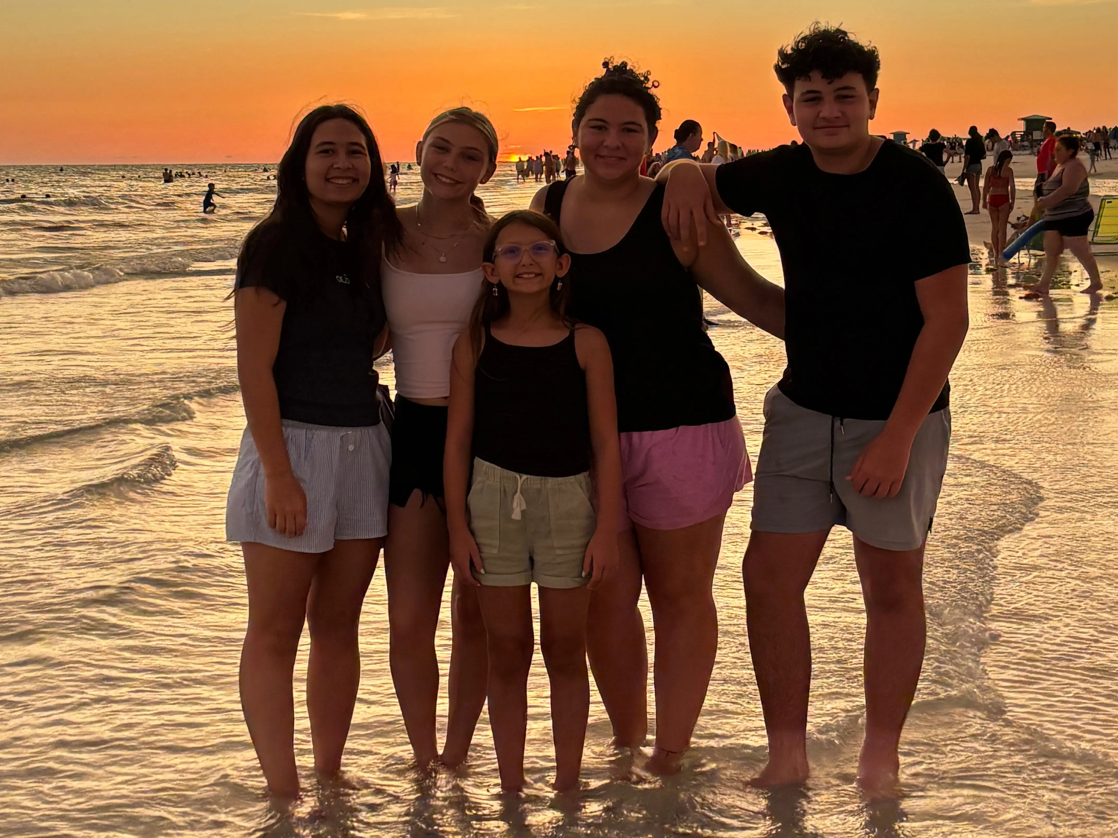 Group of people on beach at sunset