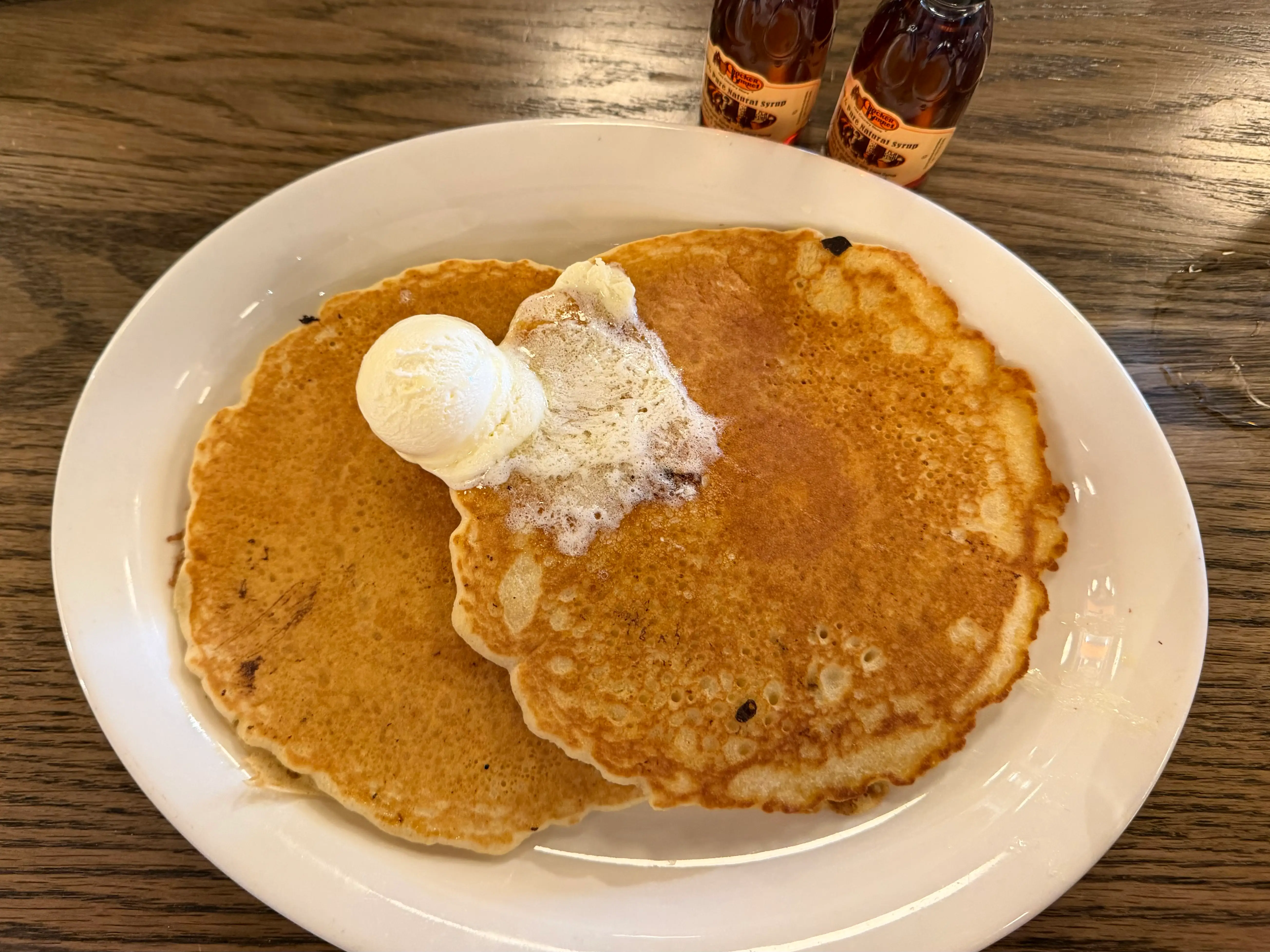 Two large pancakes on plate with butter at Cracker Barrel