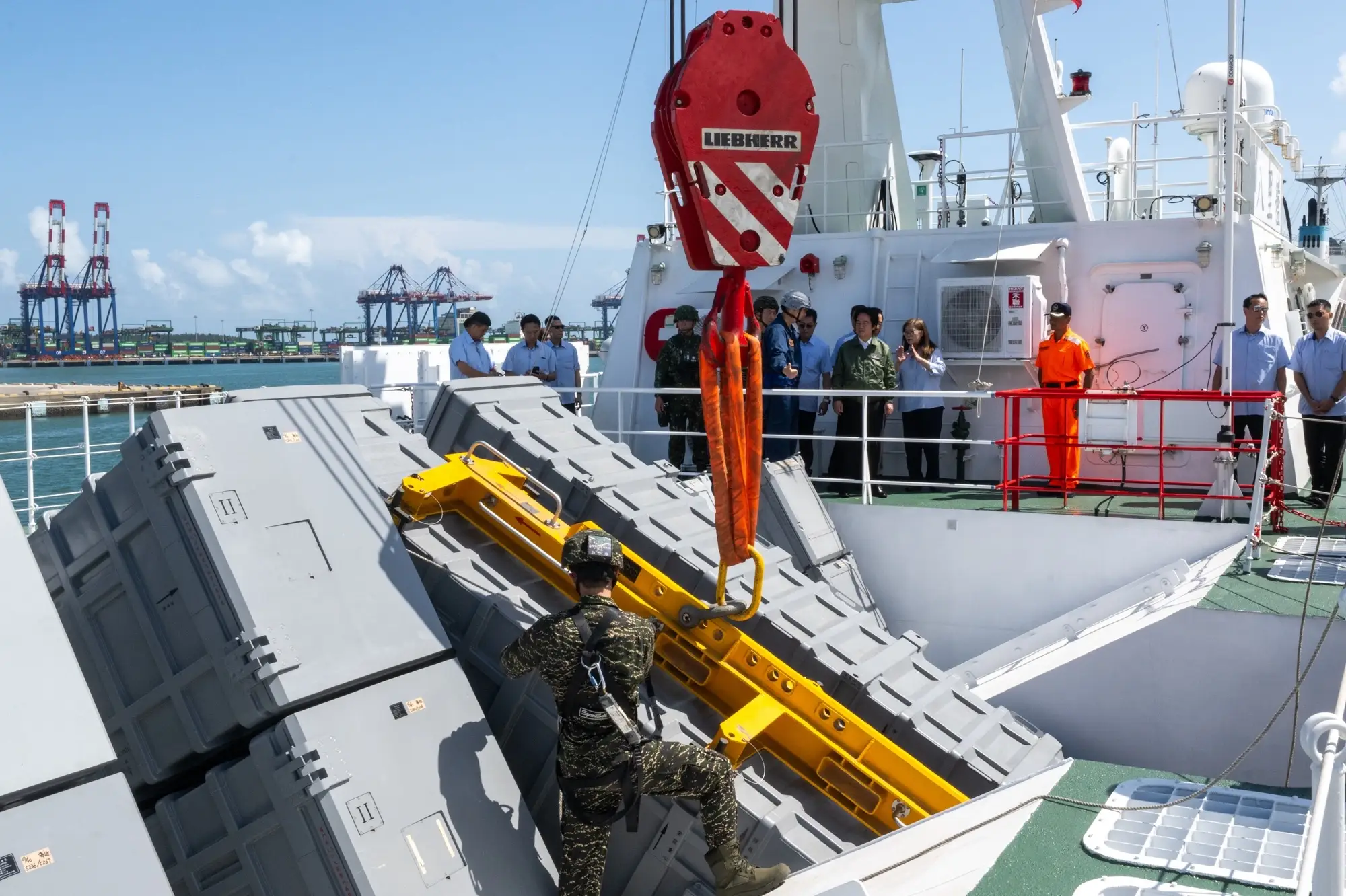 Lai Ching-te looks on as Hsiung Feng missile launchers are loaded on the Bali.