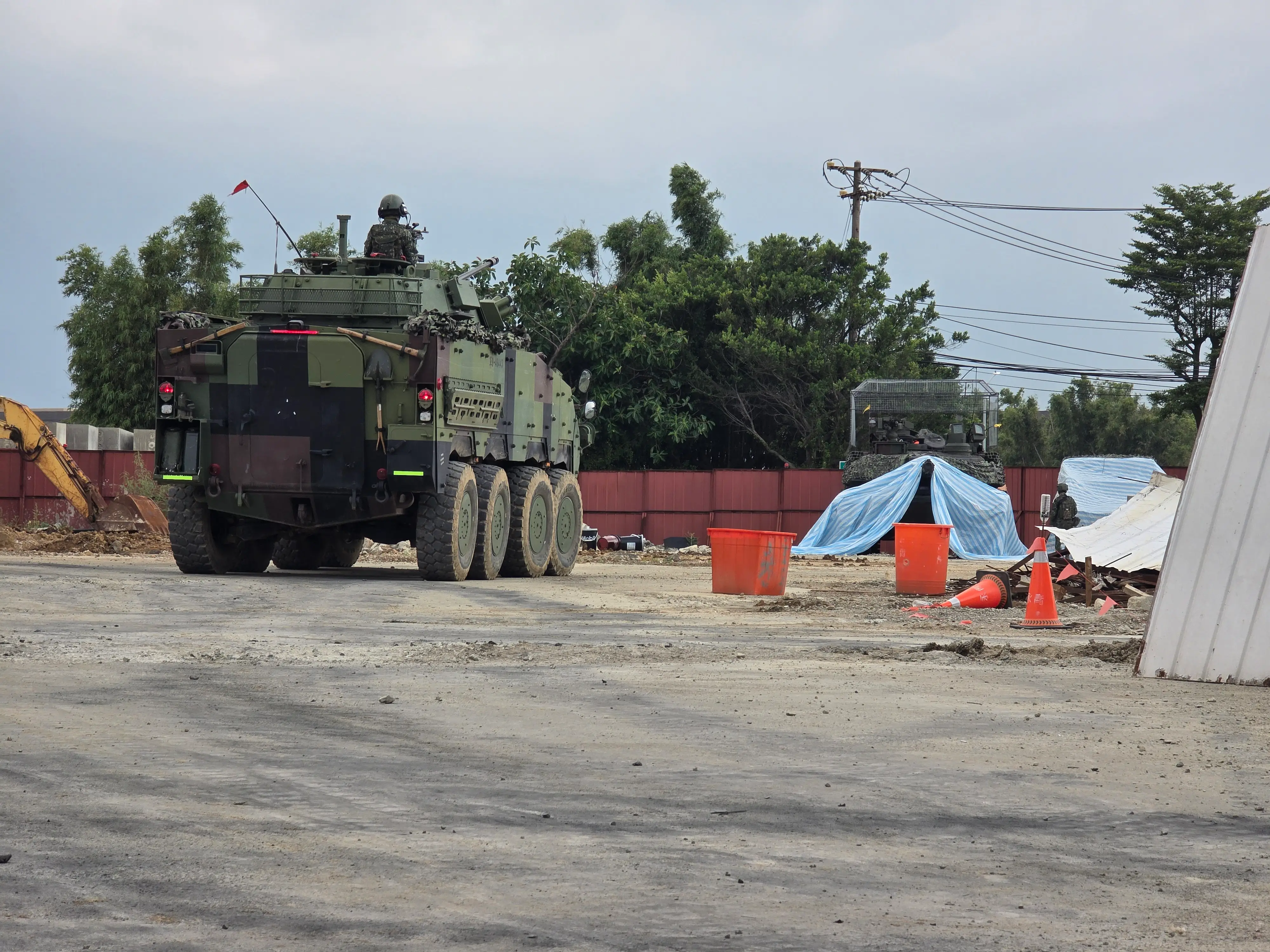A Clouded Leopard infantry fighting vehicle and an Abrams tank sit in a construction yard.