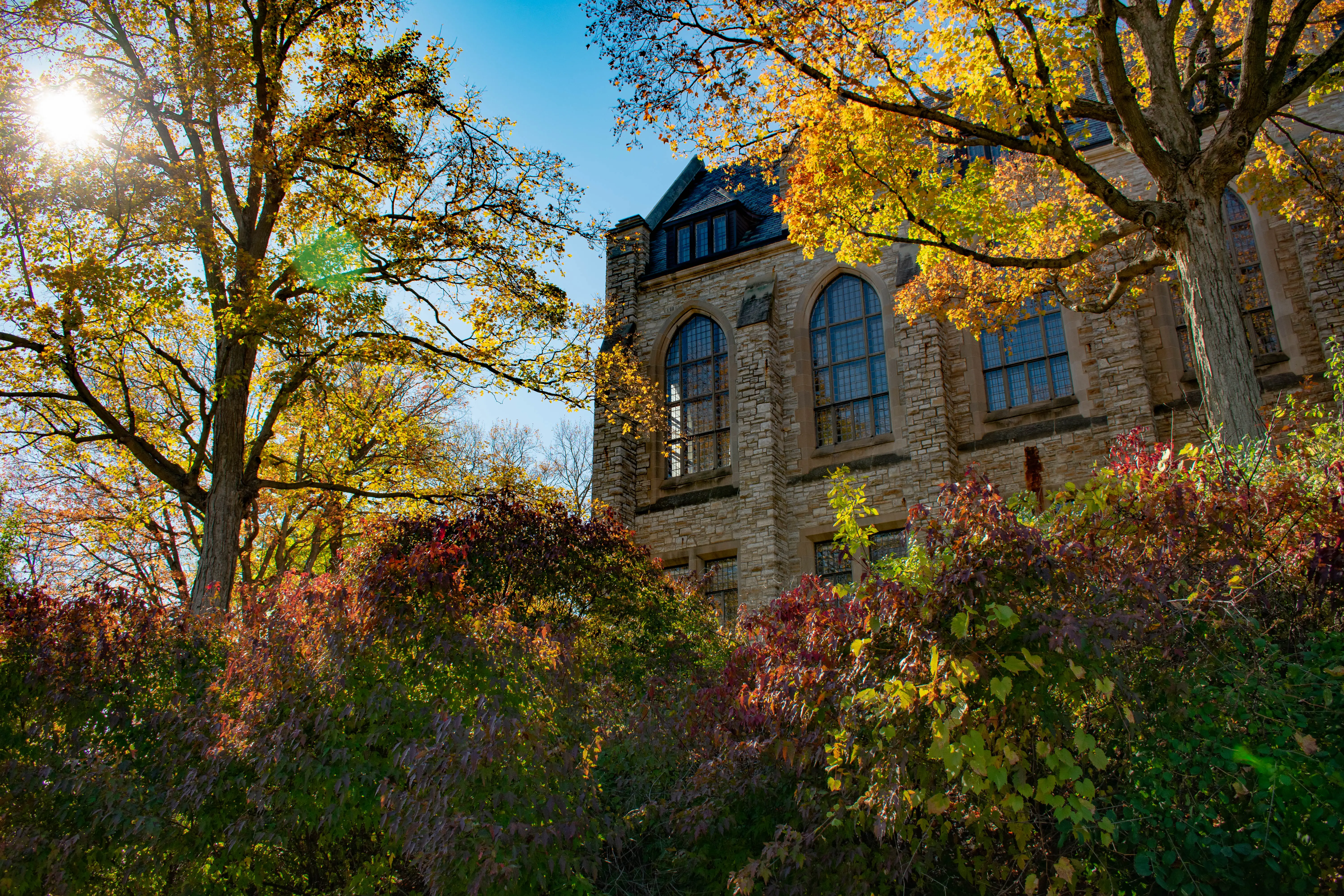 Facade of Regents Hall at St Olaf College surrounded by trees.