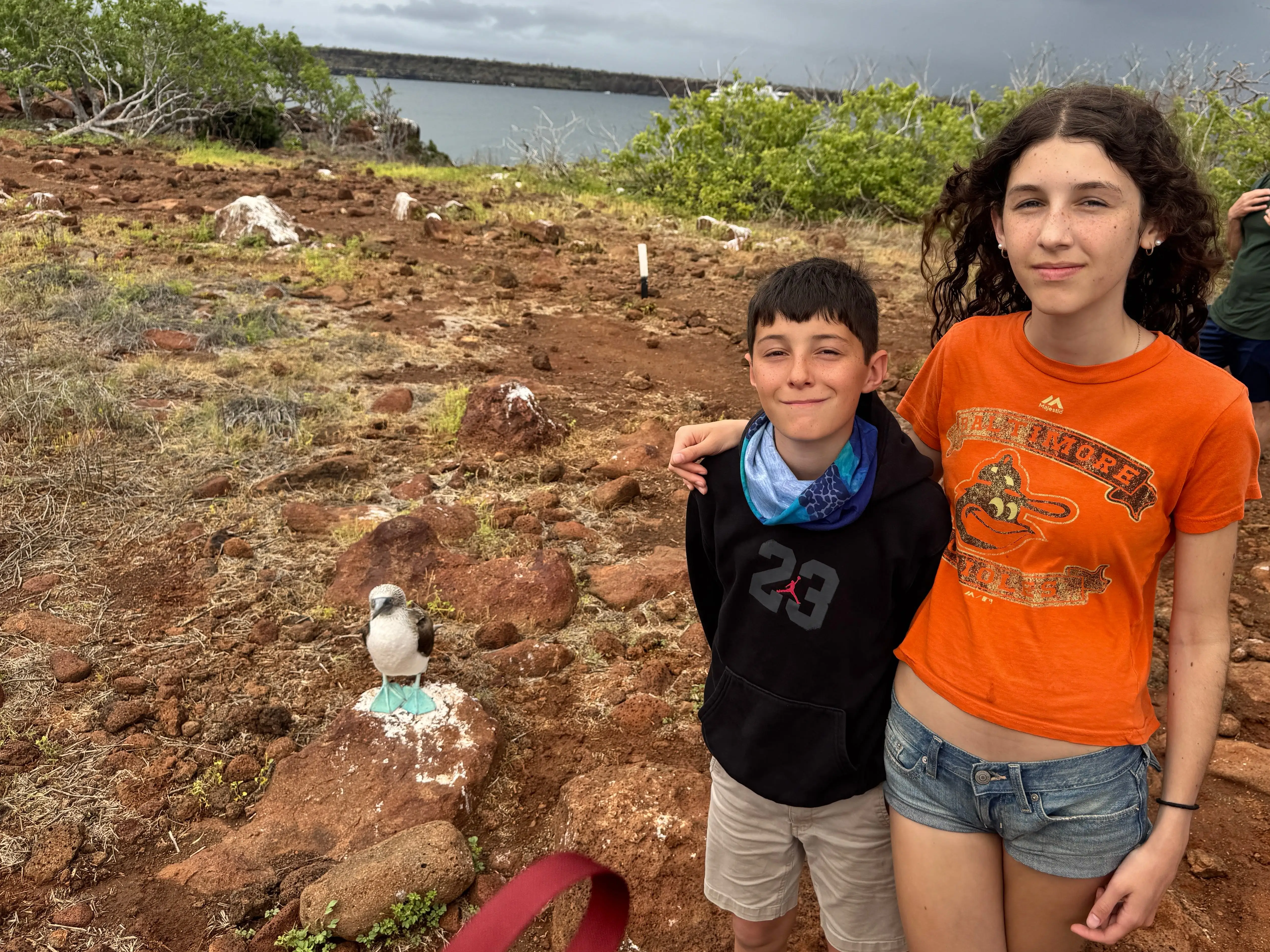 The author's children pose next to a blue-footed booby.