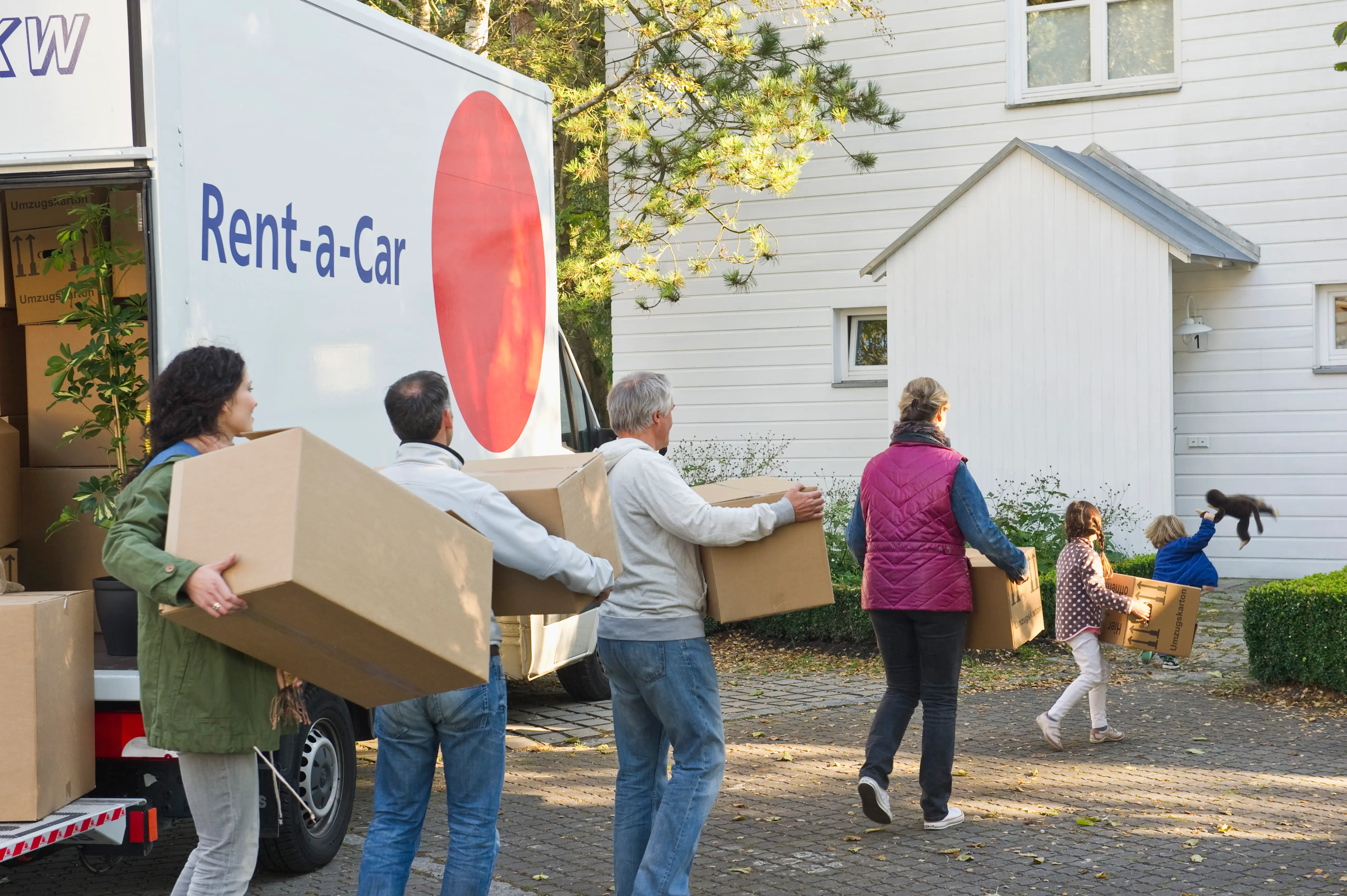 A family working together to unload moving boxes.