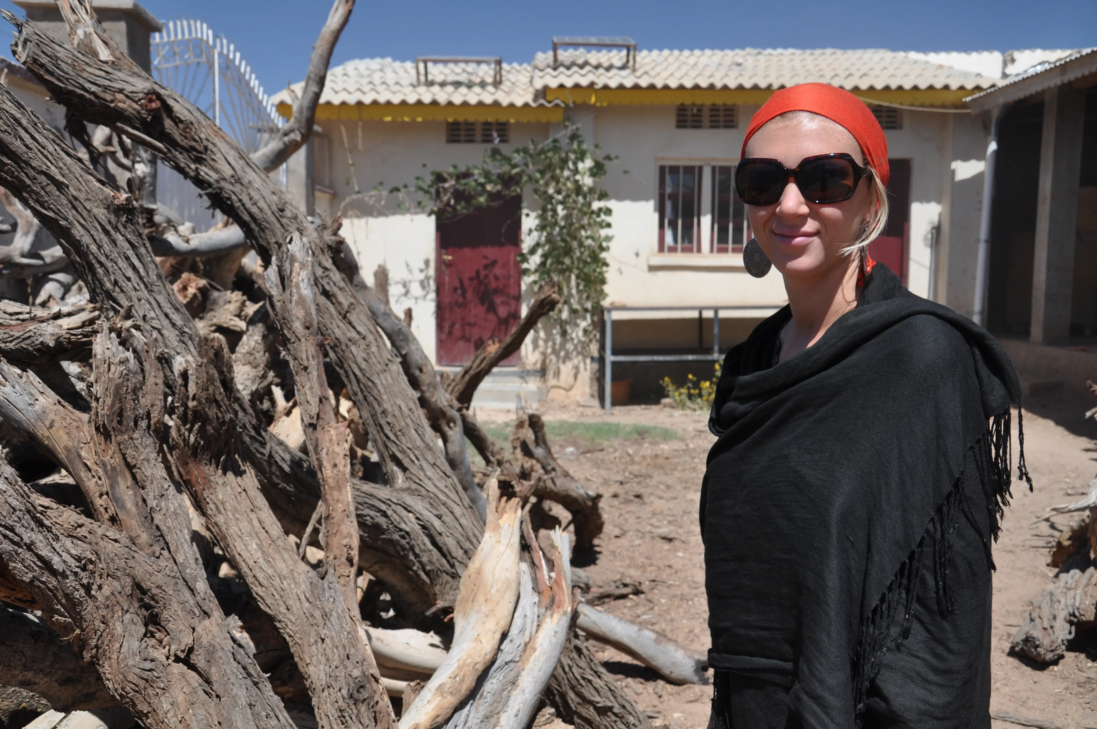 Jessica Buchanan in black shirt and red head scarf in desert.