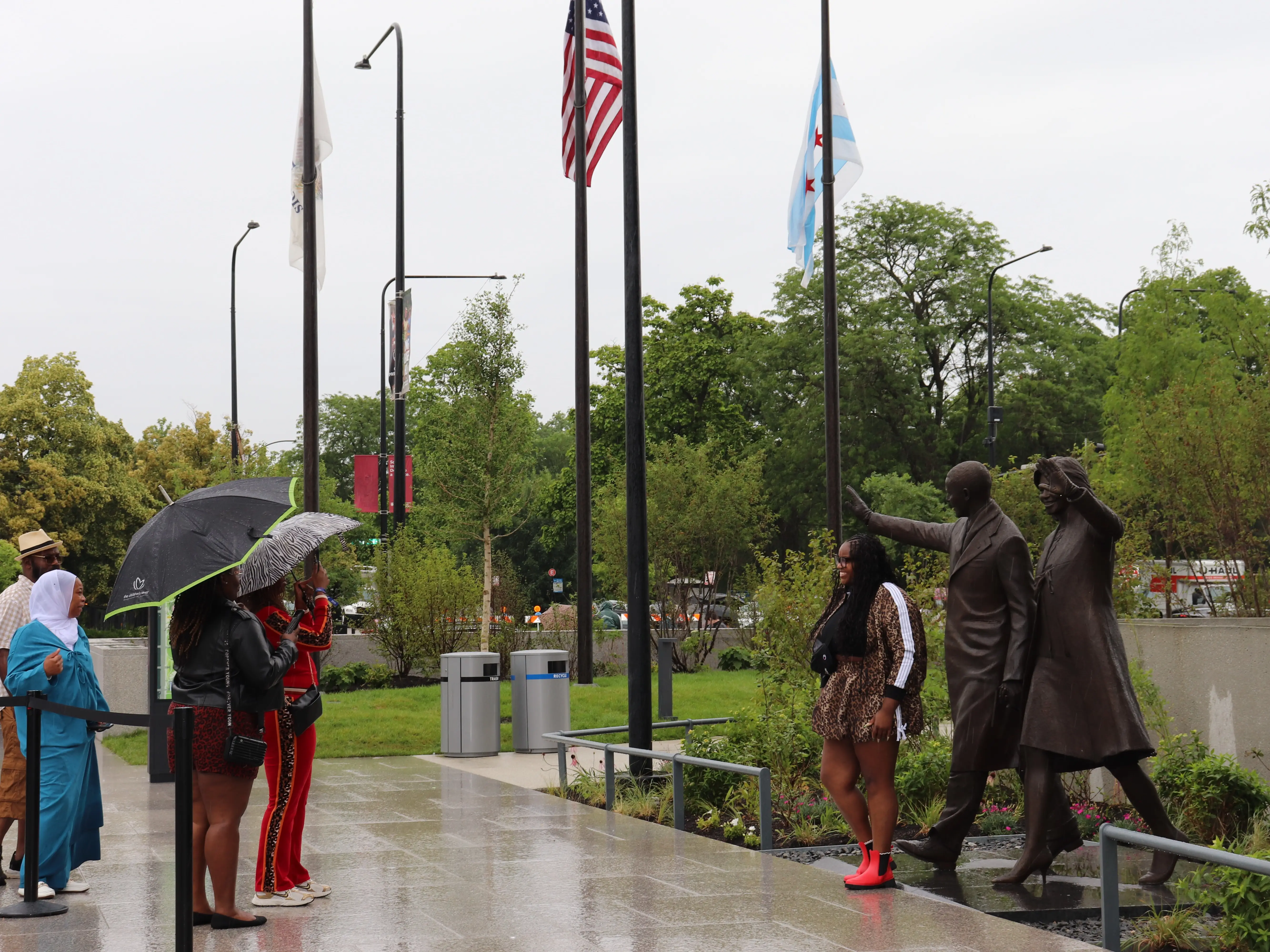 Visitors pose with statues of Barack and Michelle Obama at the Obama Presidential Center.