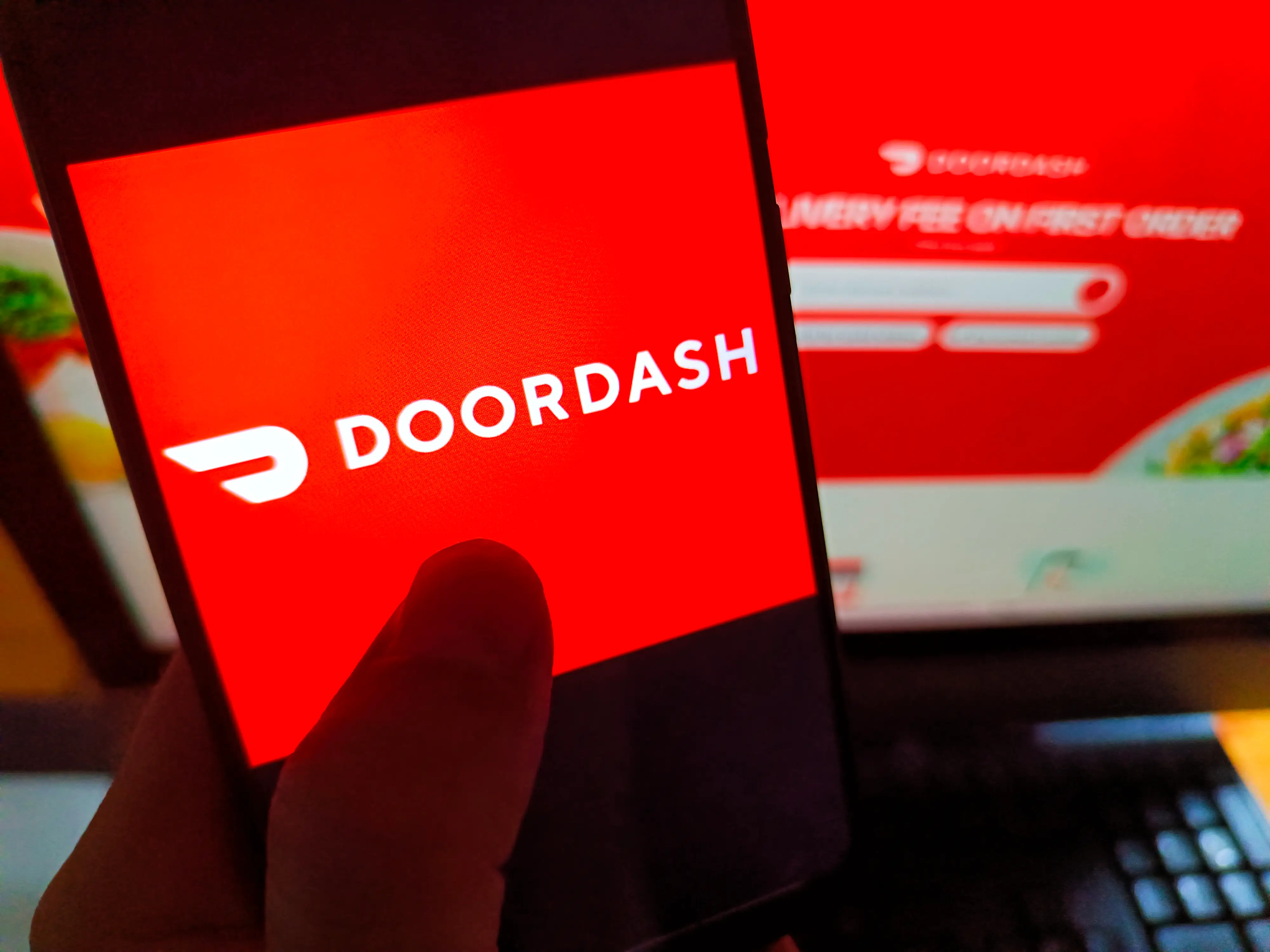 The DoorDash logo shows on a smartphone screen