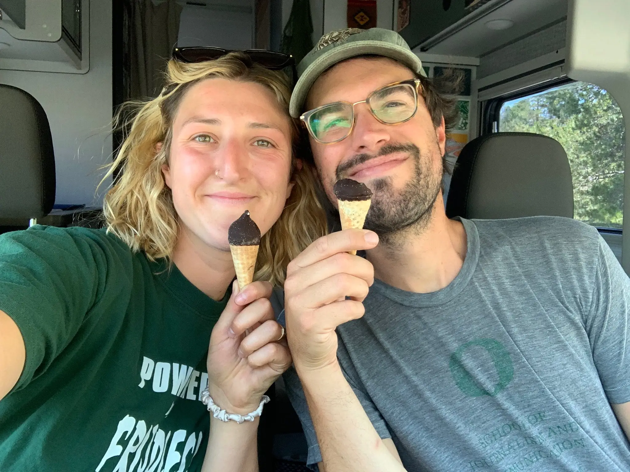 Sarah Silbiger and Jason Bernert smile as they hold two mini chocolate ice cream cones.