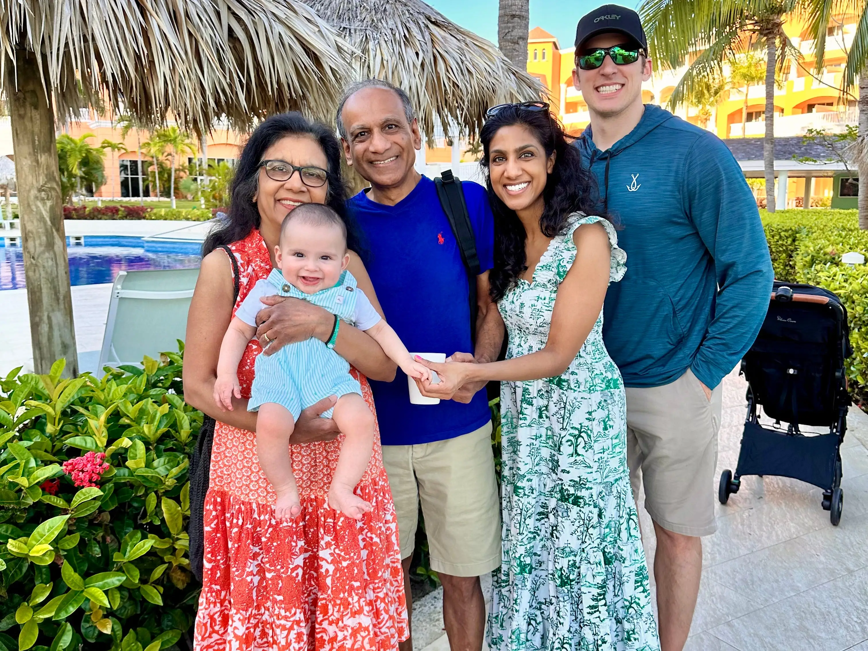 A family of five standing near a swimming pool at a resort.