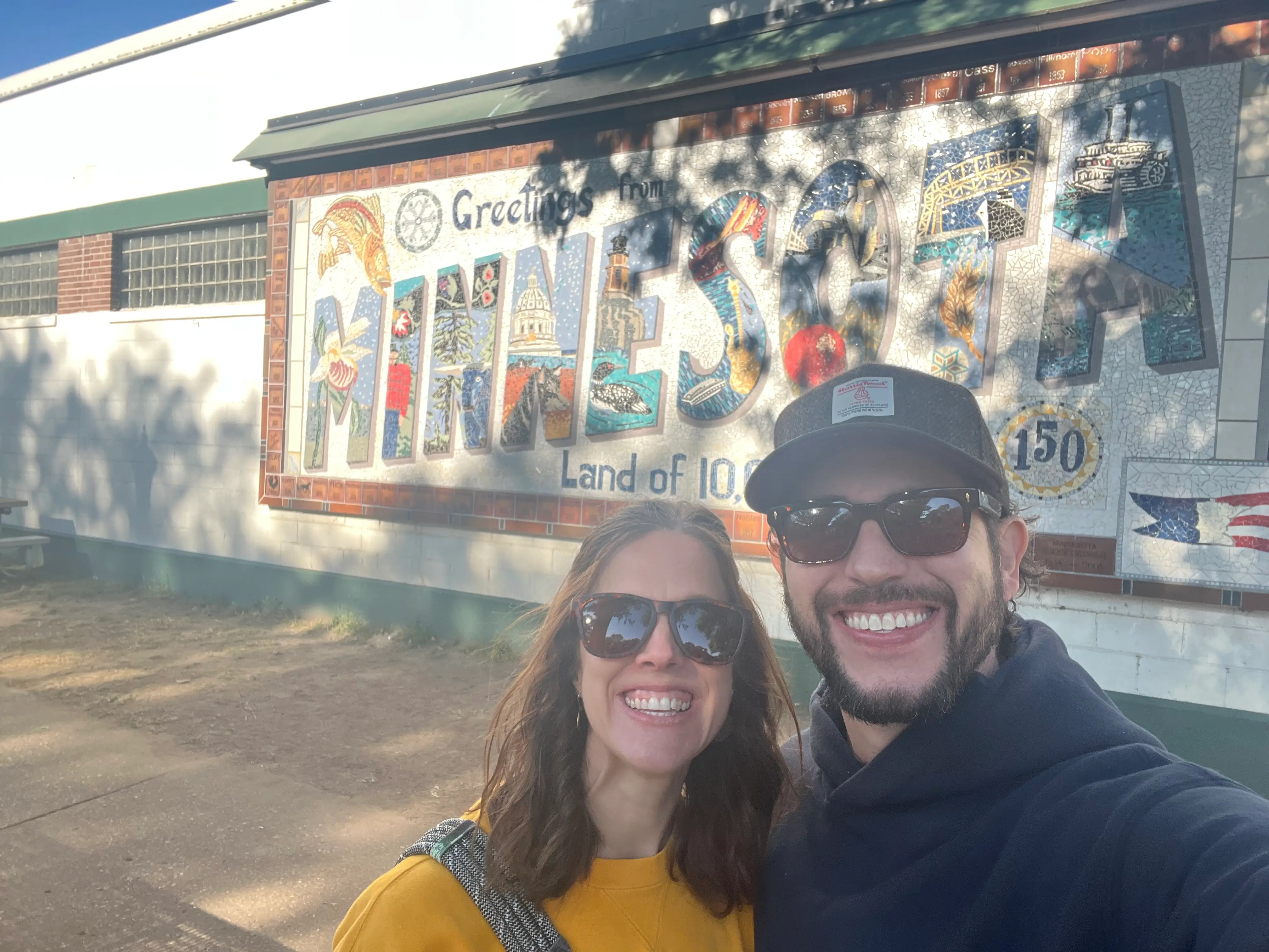 The author and her husband pose in front of a sign that reads 