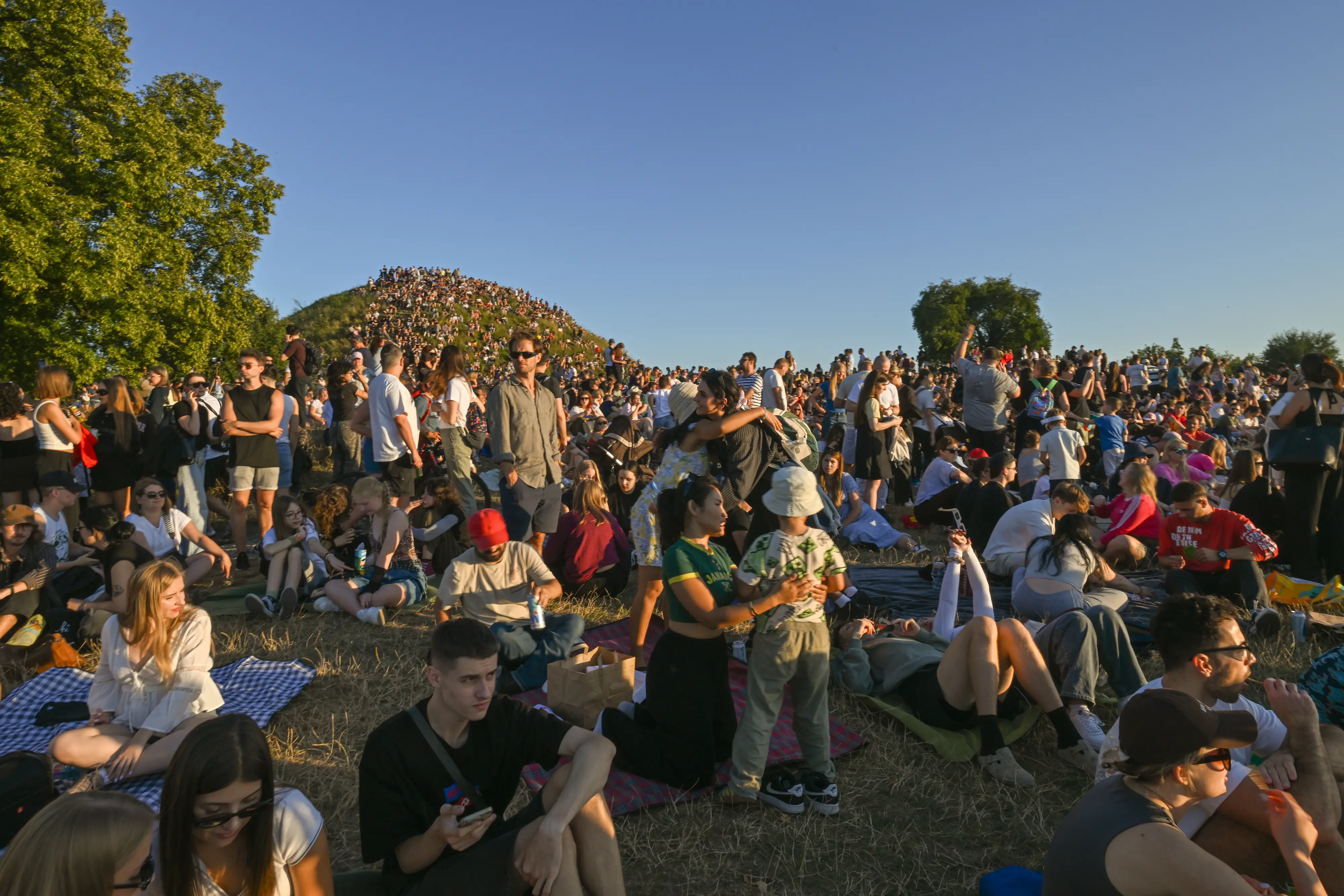 A large crowd gathers in an outside area.