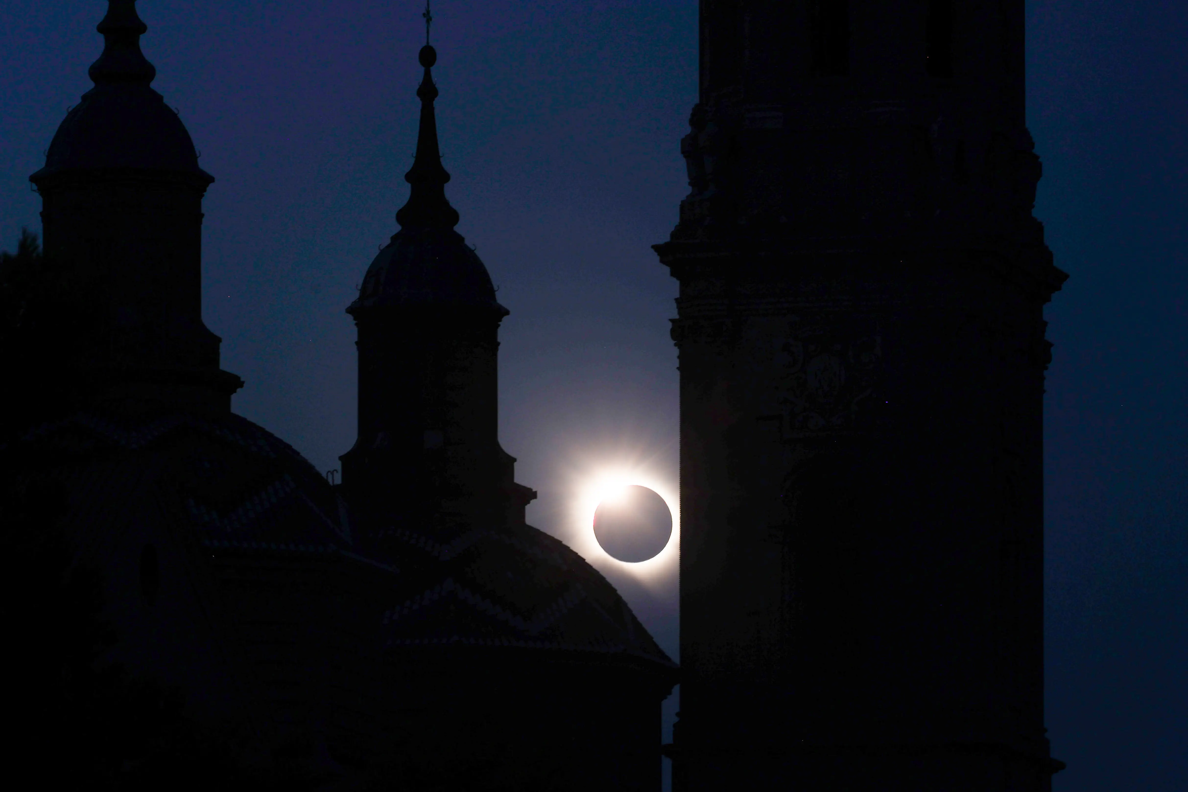 The solar eclipse is shown behind a Spanish cathedral.