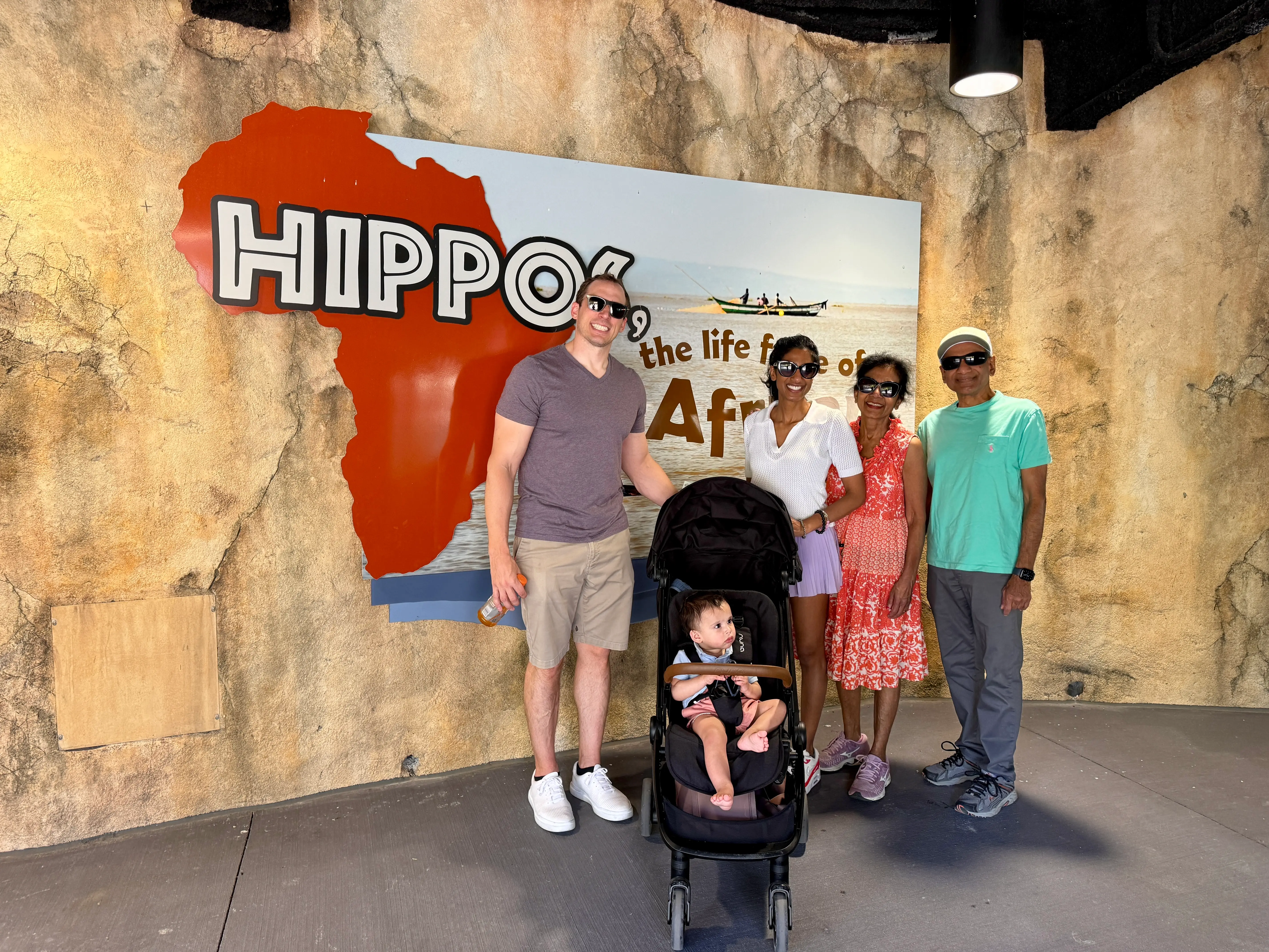 A family — including a child in a stroller — at a zoo.