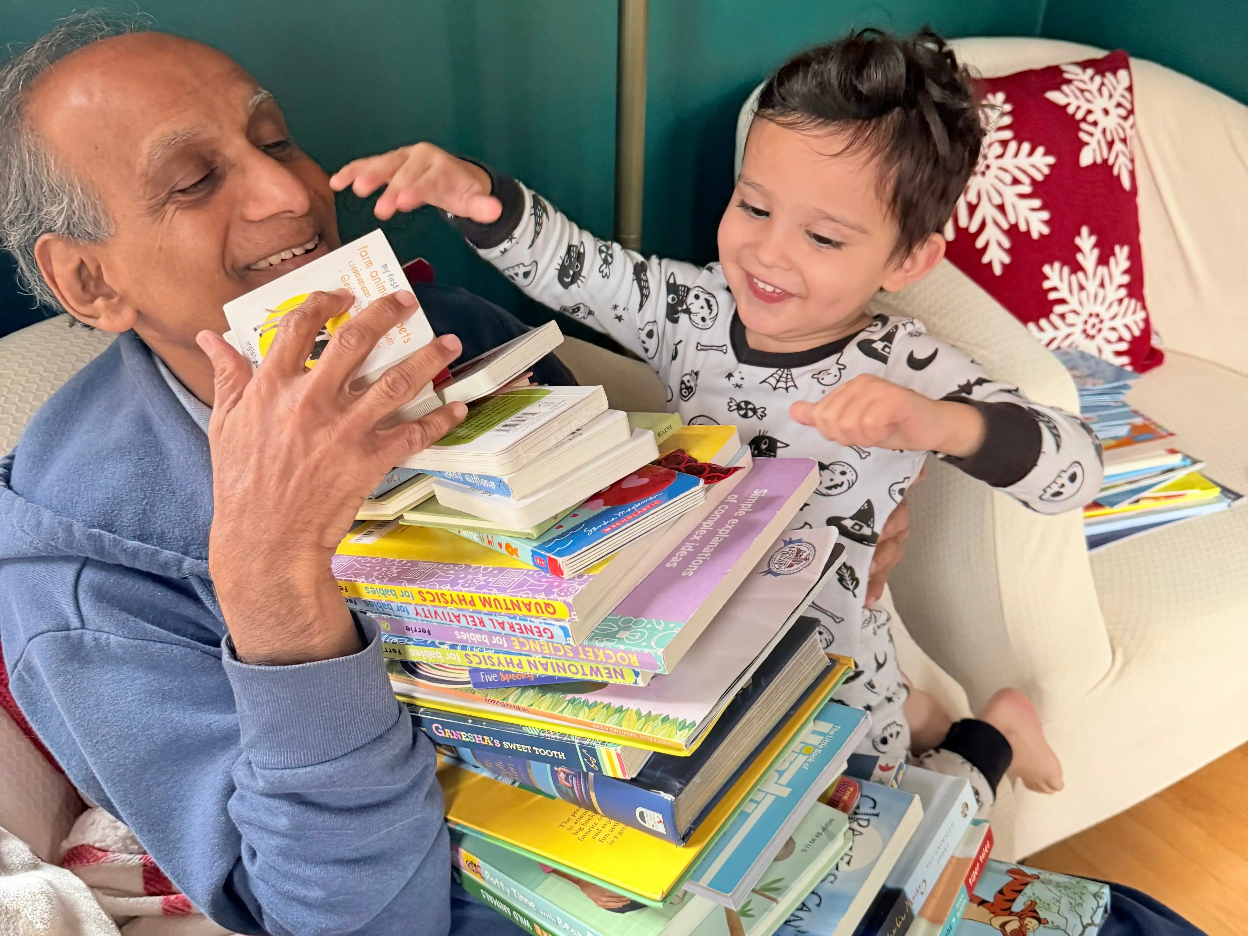 An older man with a pile of books and his grandson.