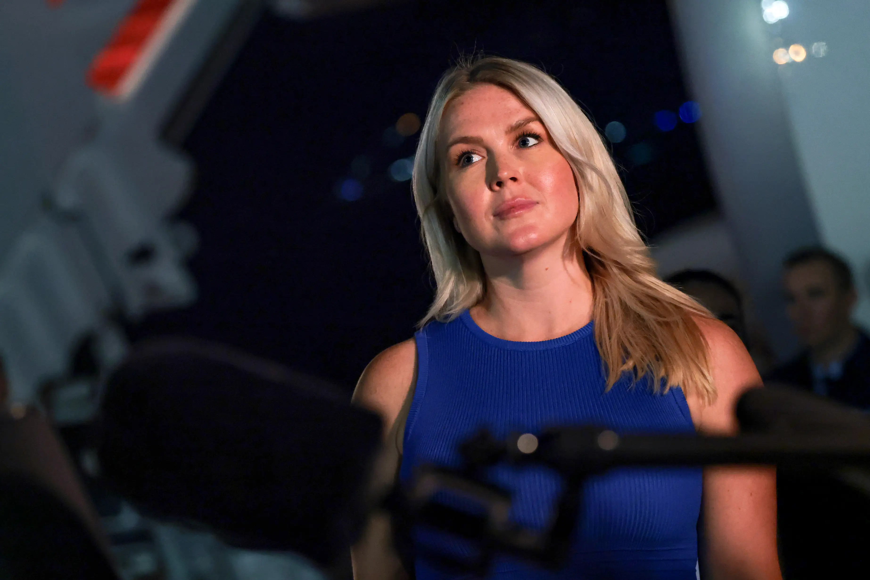 White House Press Secretary Karoline Leavitt looks on as U.S. President Donald Trump speaks to reporters after stepping off Air Force One on August 11, 2026 in Joint Base Andrews, Maryland. Trump was asked about the secret decoy flight he took out of Turkey in a military aircraft. The