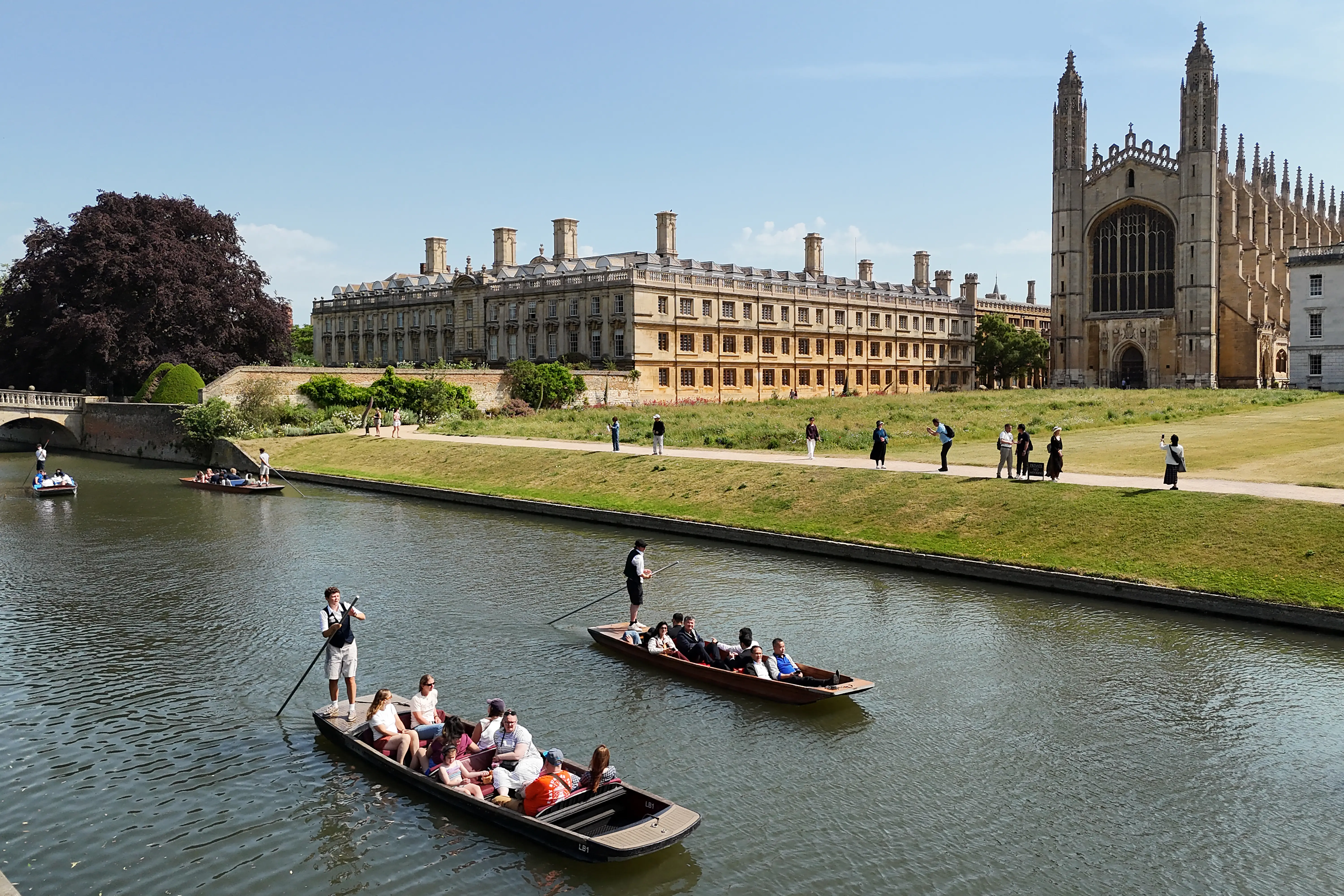 People enjoy a punt tour past Clare College and King's College Chapel on the River Cam in Cambridge.