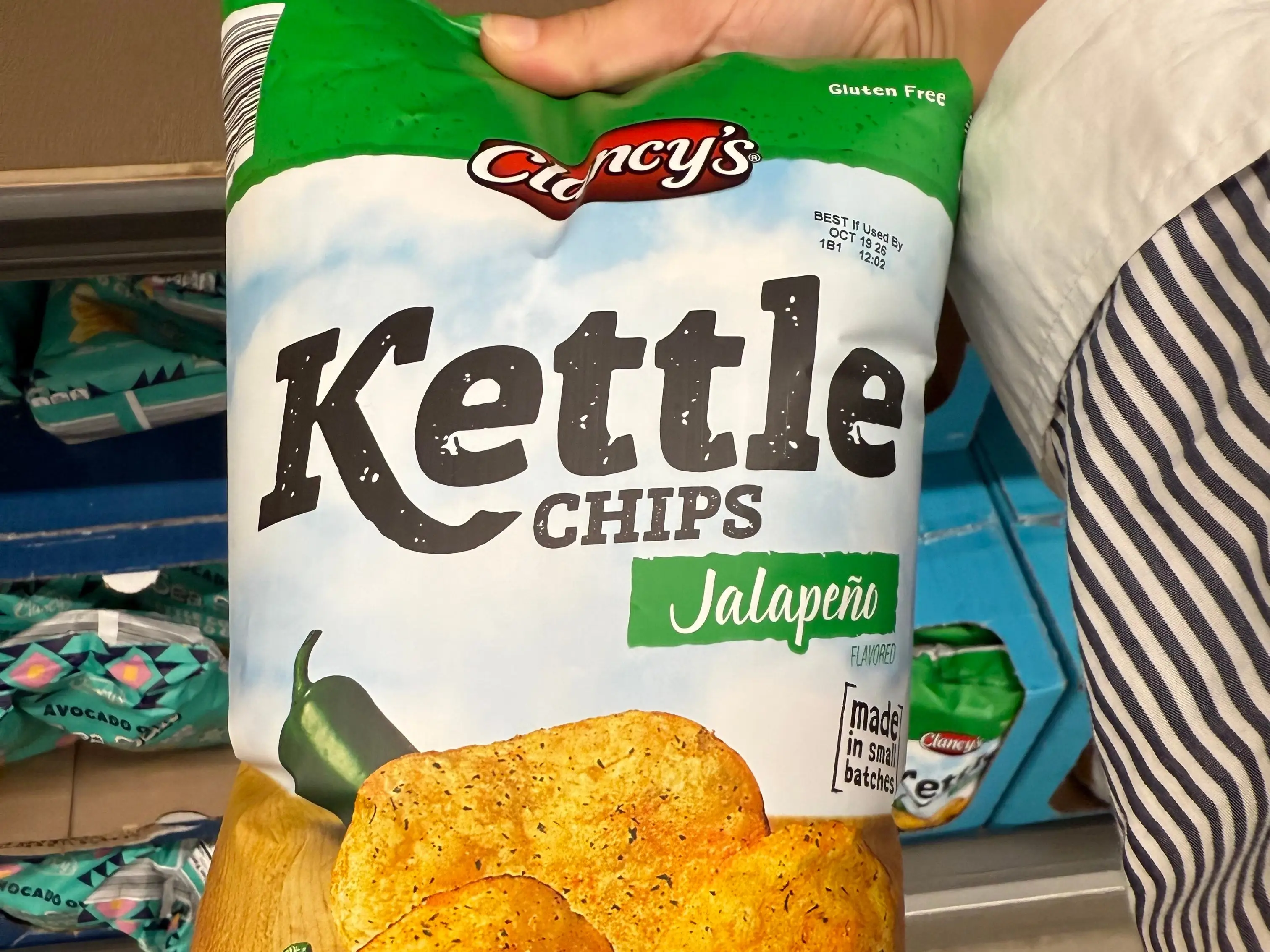 The writer is holding a bag of Clancy's jalapeño kettle chips at Aldi.