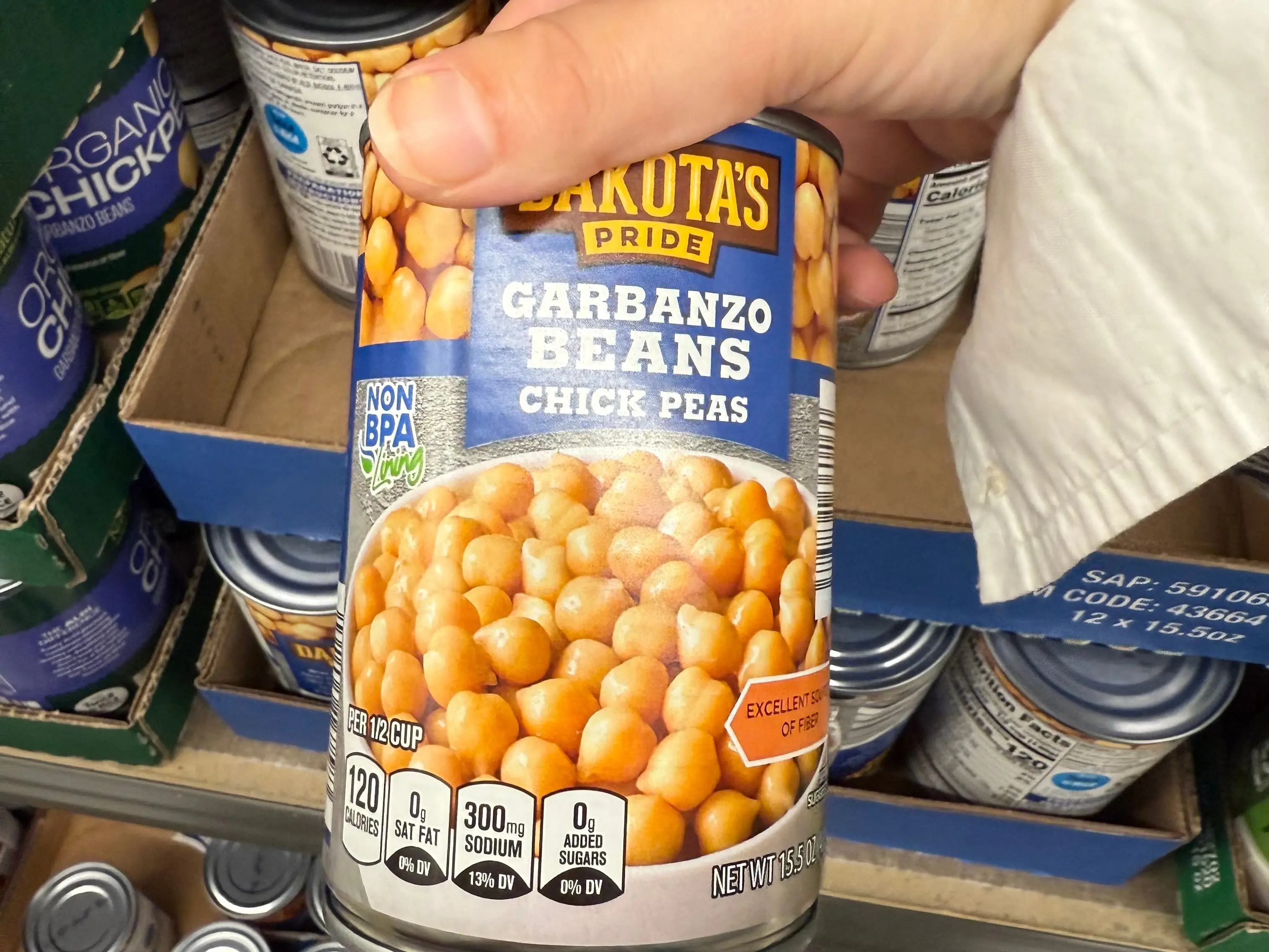 The writer is holding a can of Dakota's Pride garbanzo beans at Aldi.