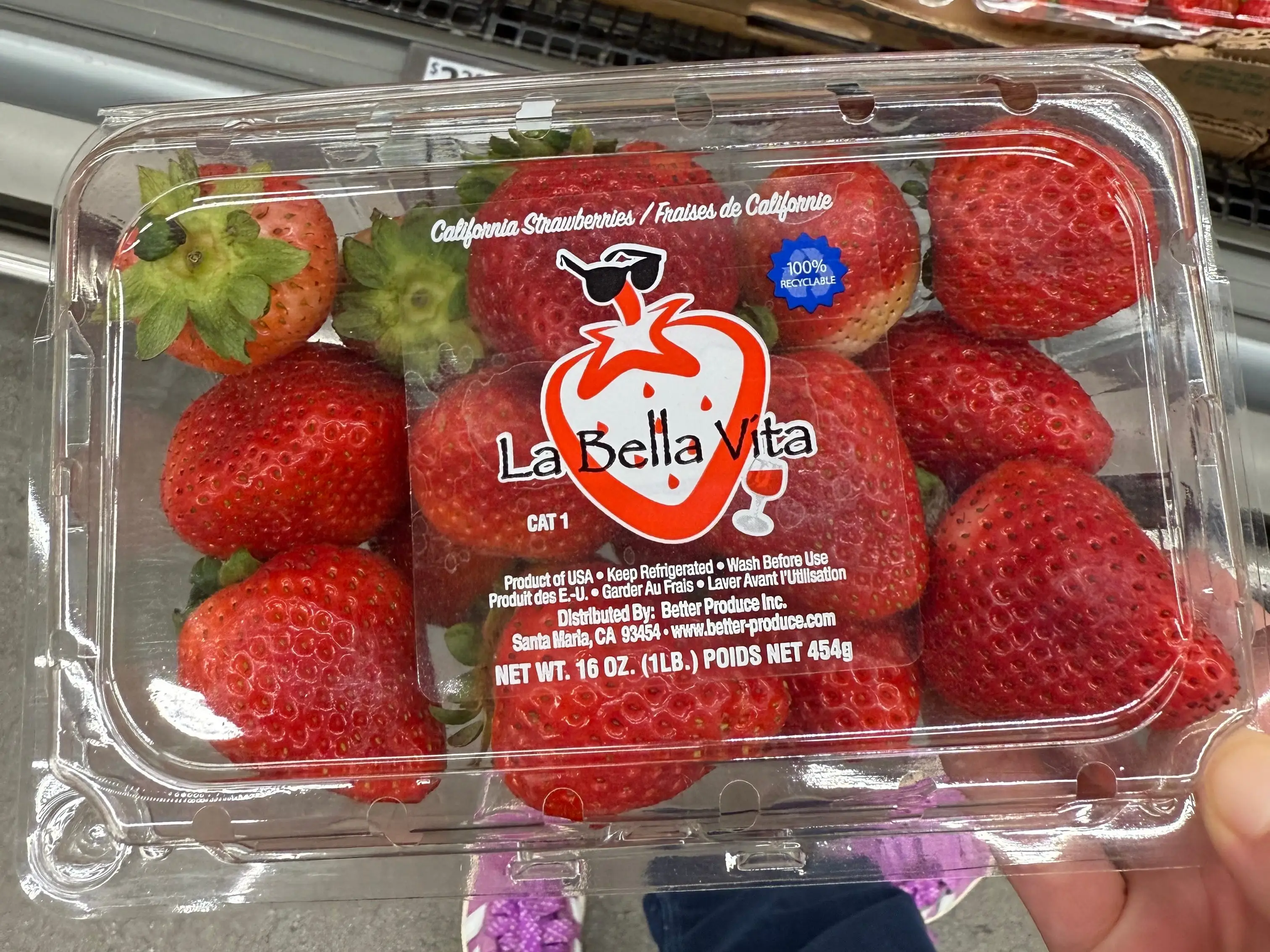 The writer is holding a container of La Bella Vita strawberries at Aldi.