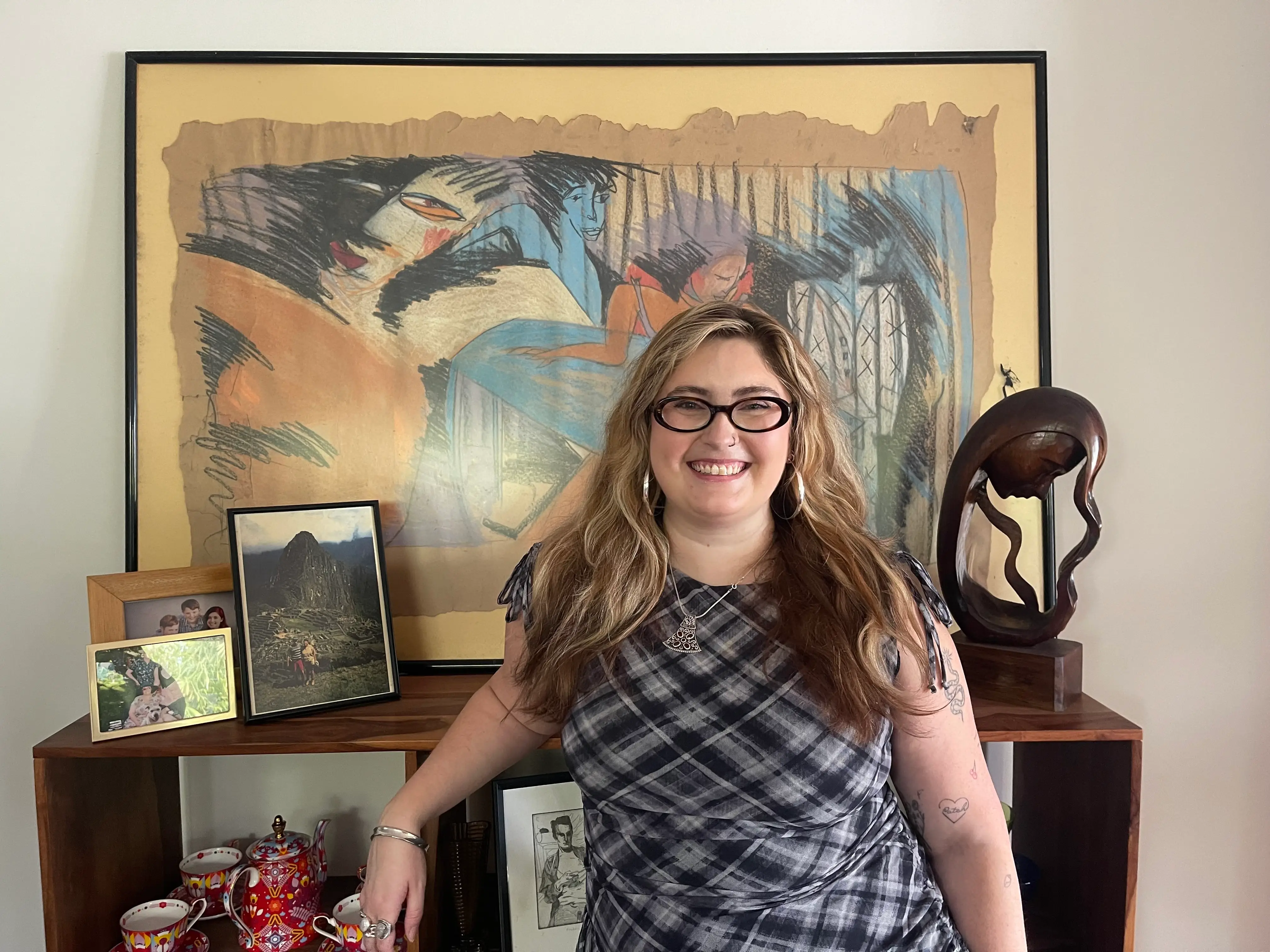 Billie Schwab Dunn poses in front of art in her family's home.