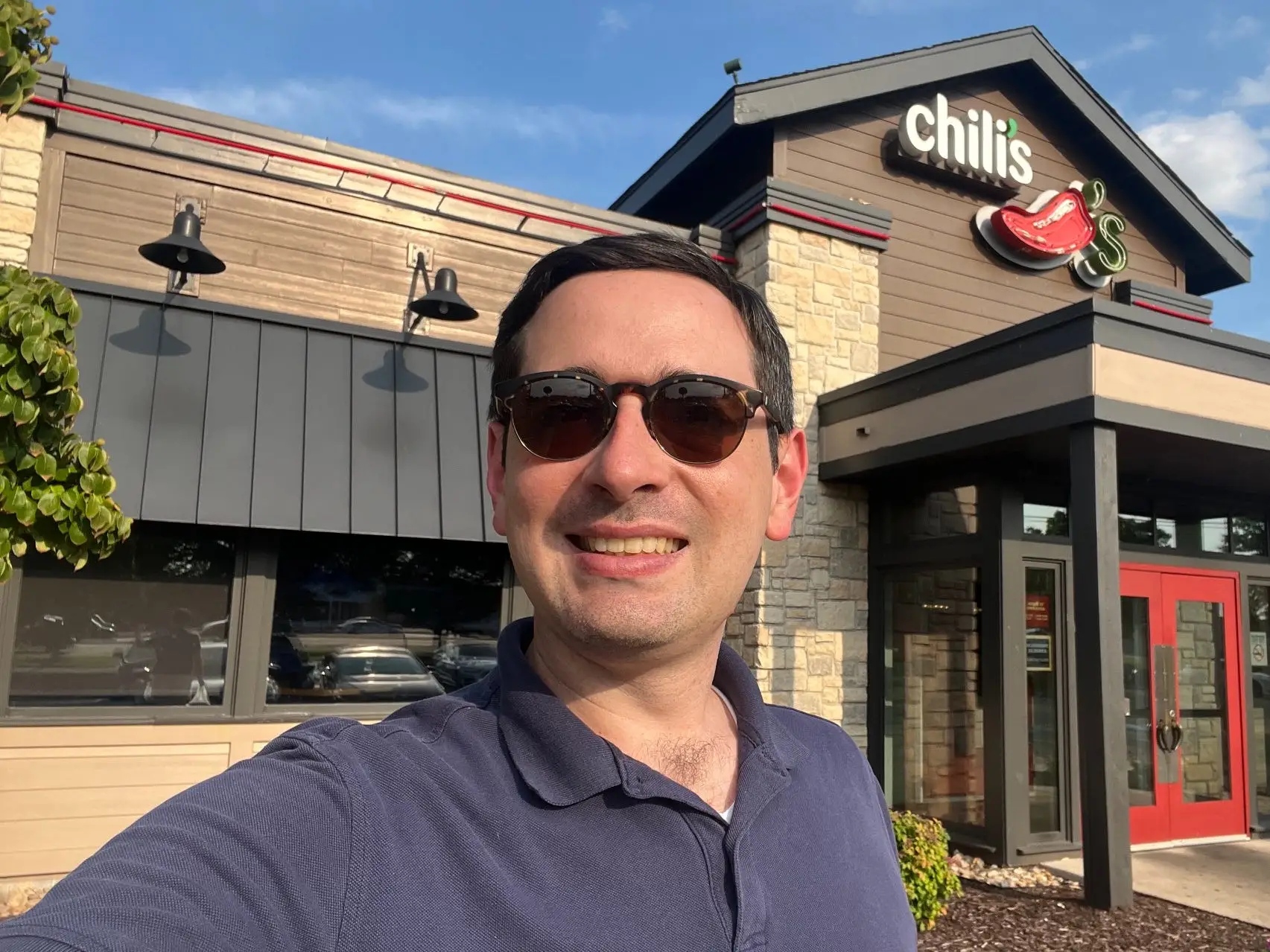 The reporter stands outside of the entrance of a Chili's restaurant.