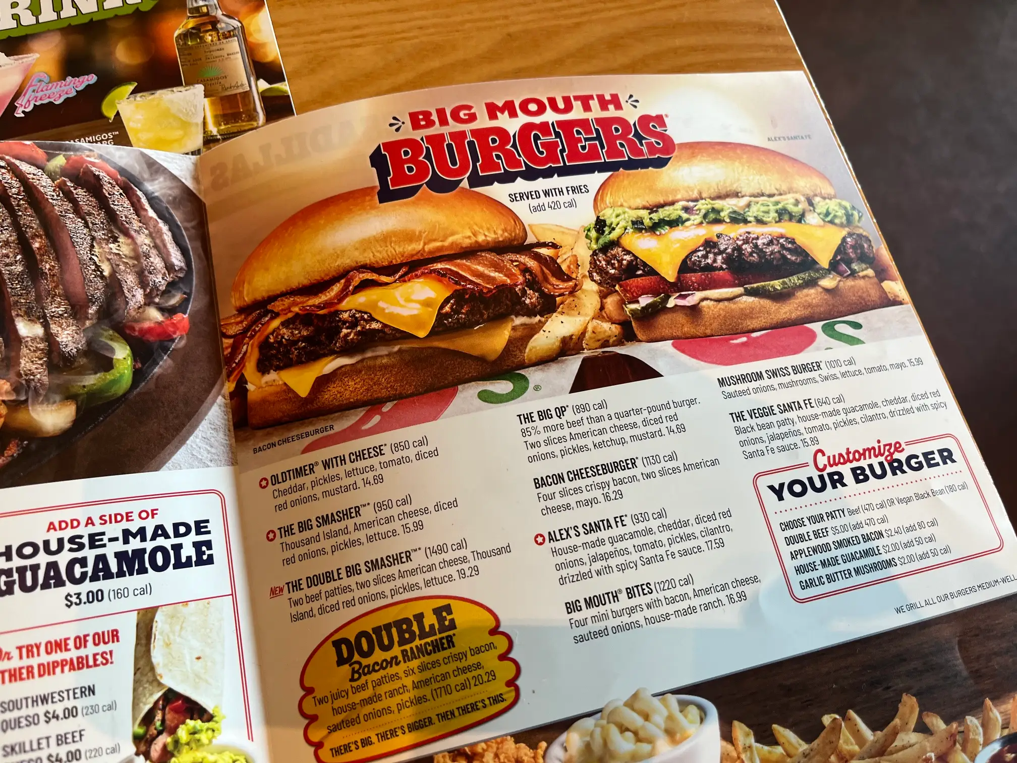 Restaurant menu spread highlights Big Mouth Burgers with large burger photos, customization options, and guacamole add-on pricing.