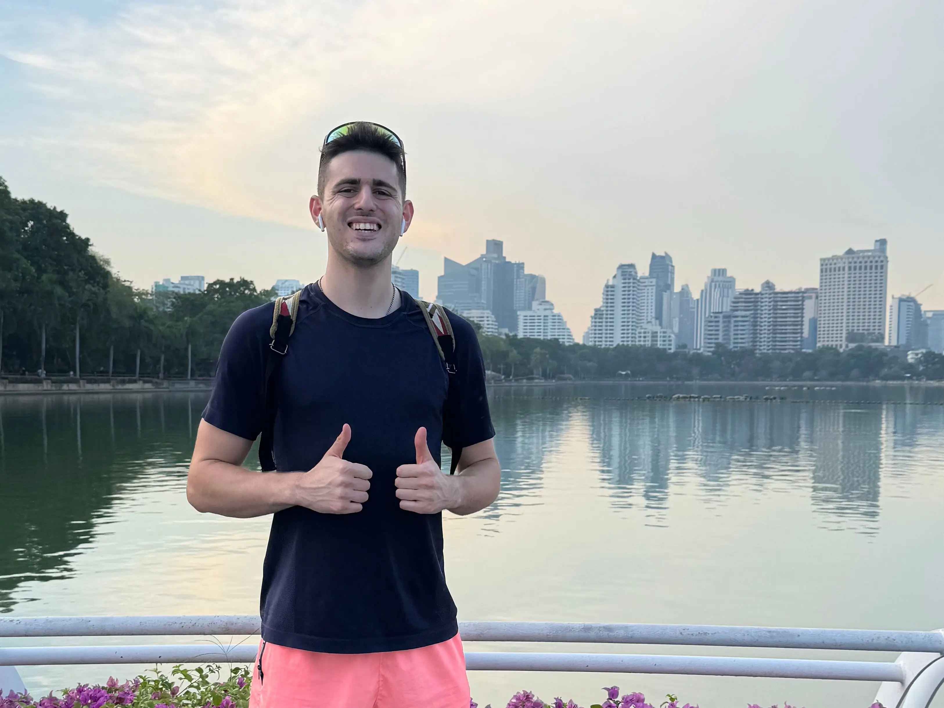 Man giving two thumbs up in front of city skyline