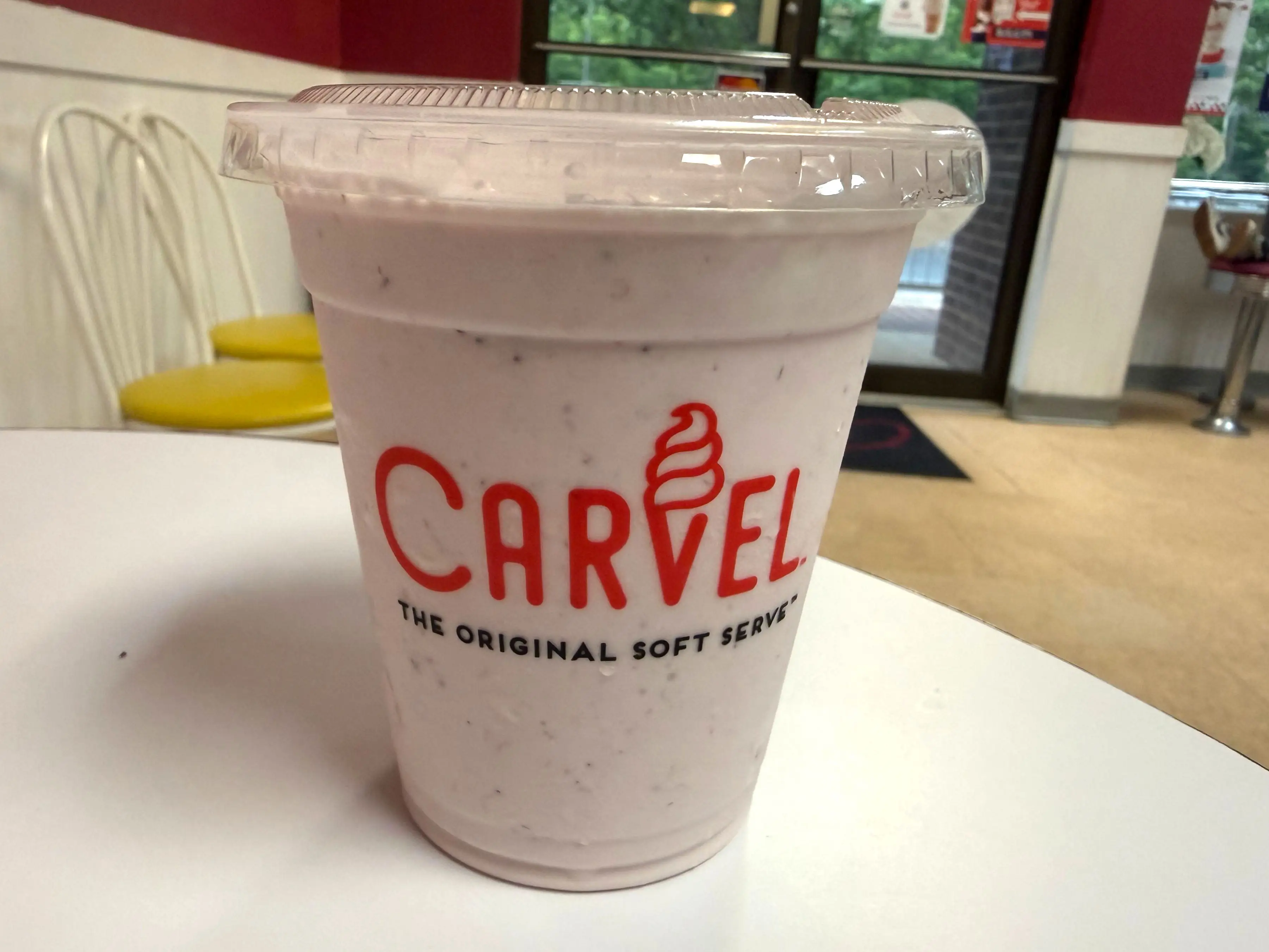 A strawberry milkshake from Carvel on a table.