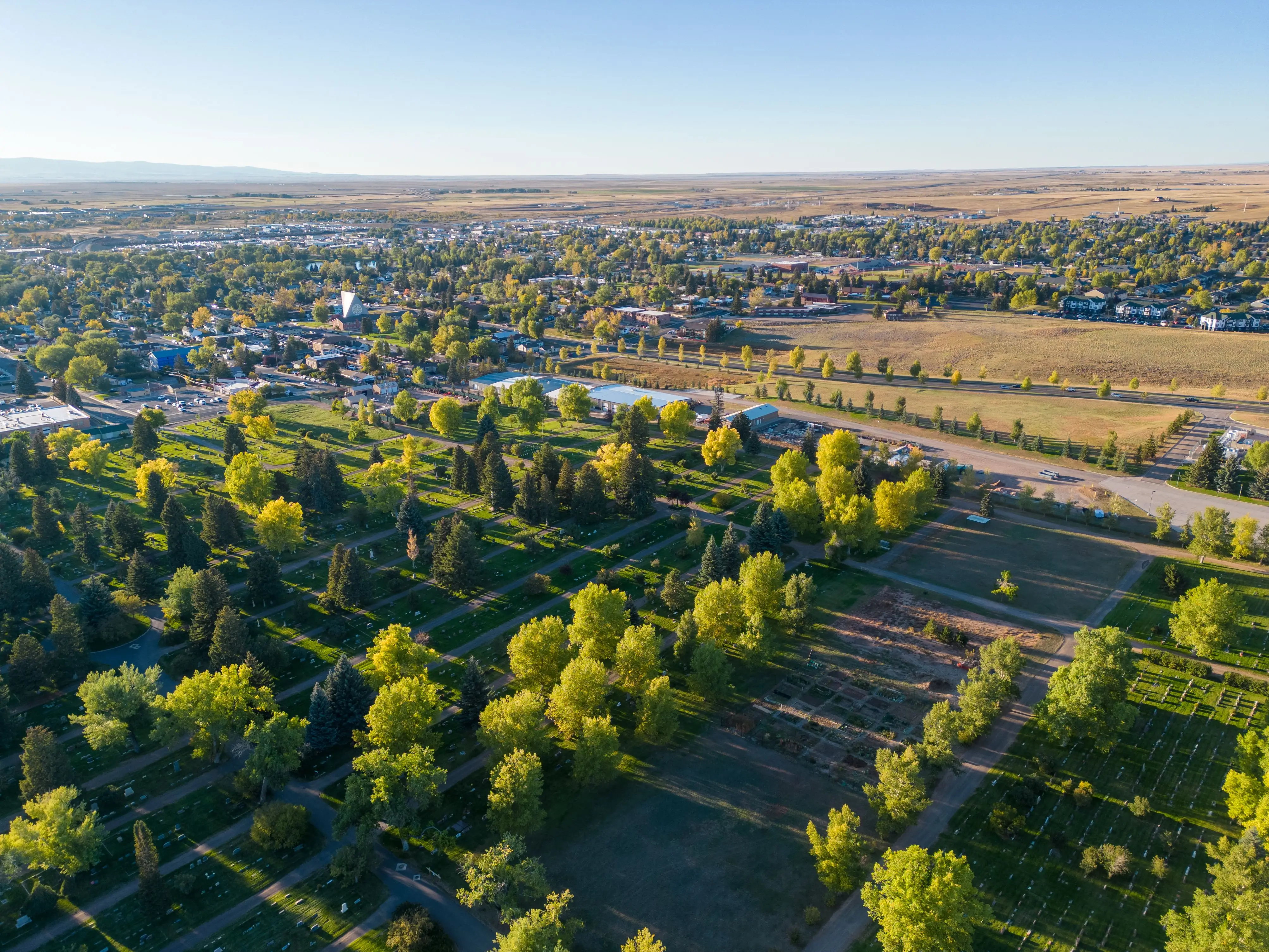 A drone shot of Laramie Wyoming neighborhood's cityscape near University of Wyoming with farmland and sunlight