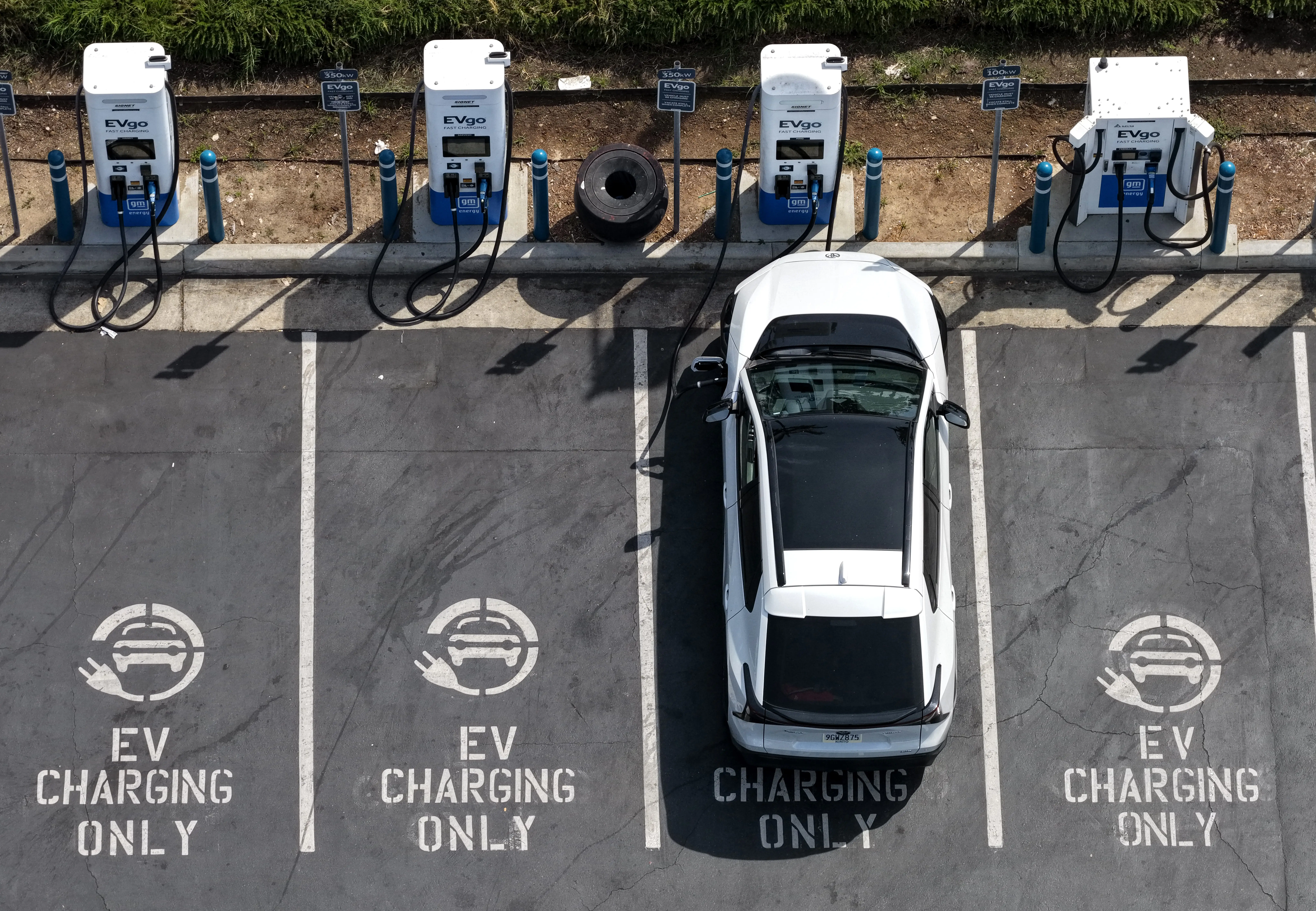 A white Toyota bZ charges at an EVgo fast-charging station.