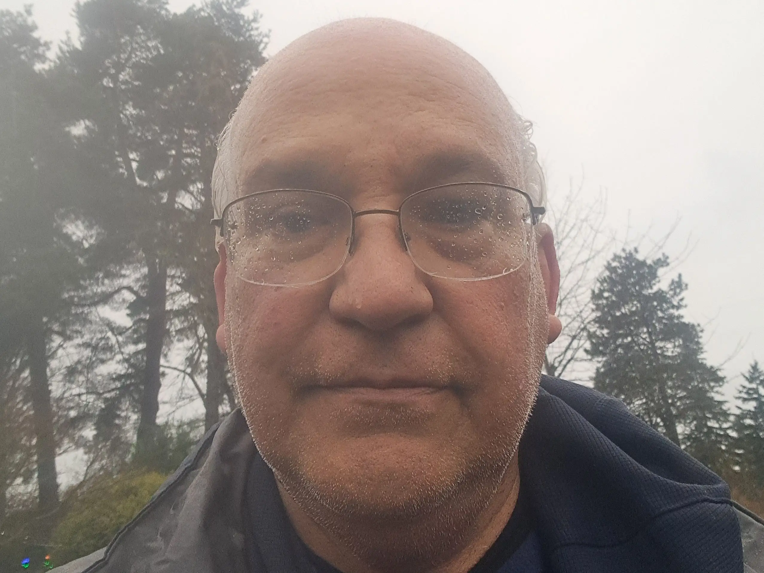 A middle-aged man with trees behind him.