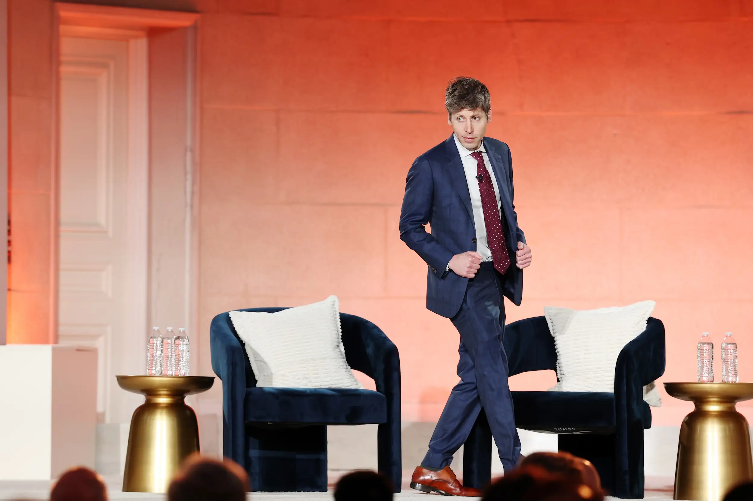 OpenAI CEO Sam Altman walks on stage at an event