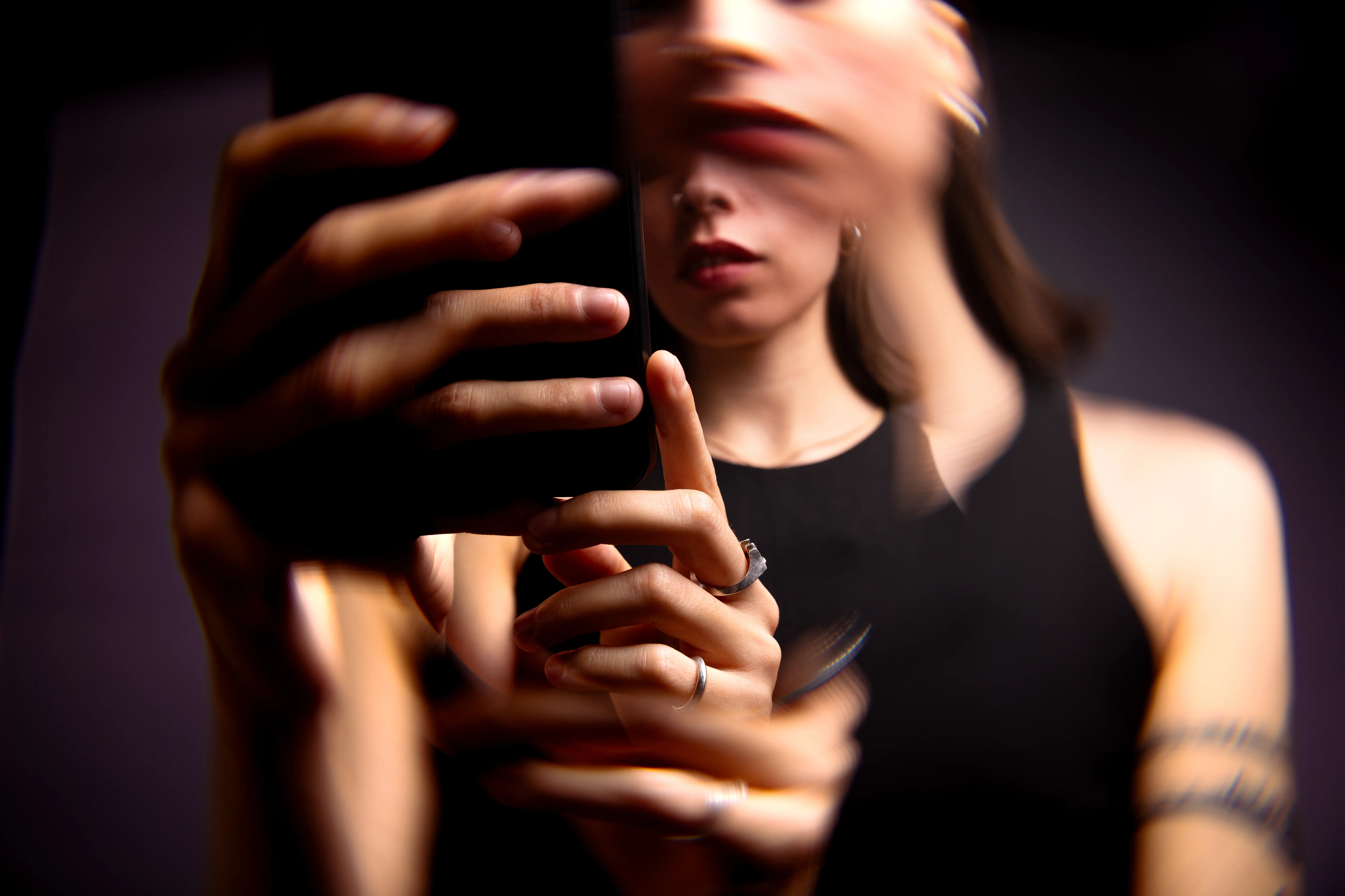 An artistically warped image of a woman on a smartphone.