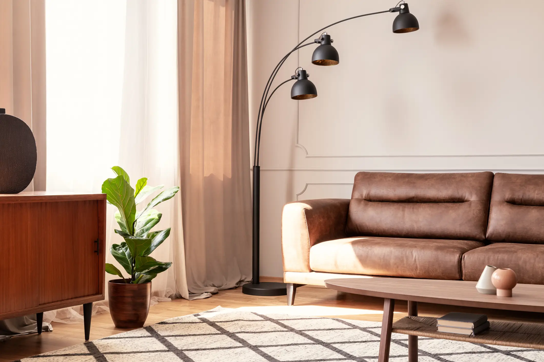 Black lamp next to leather sofa in retro living room
