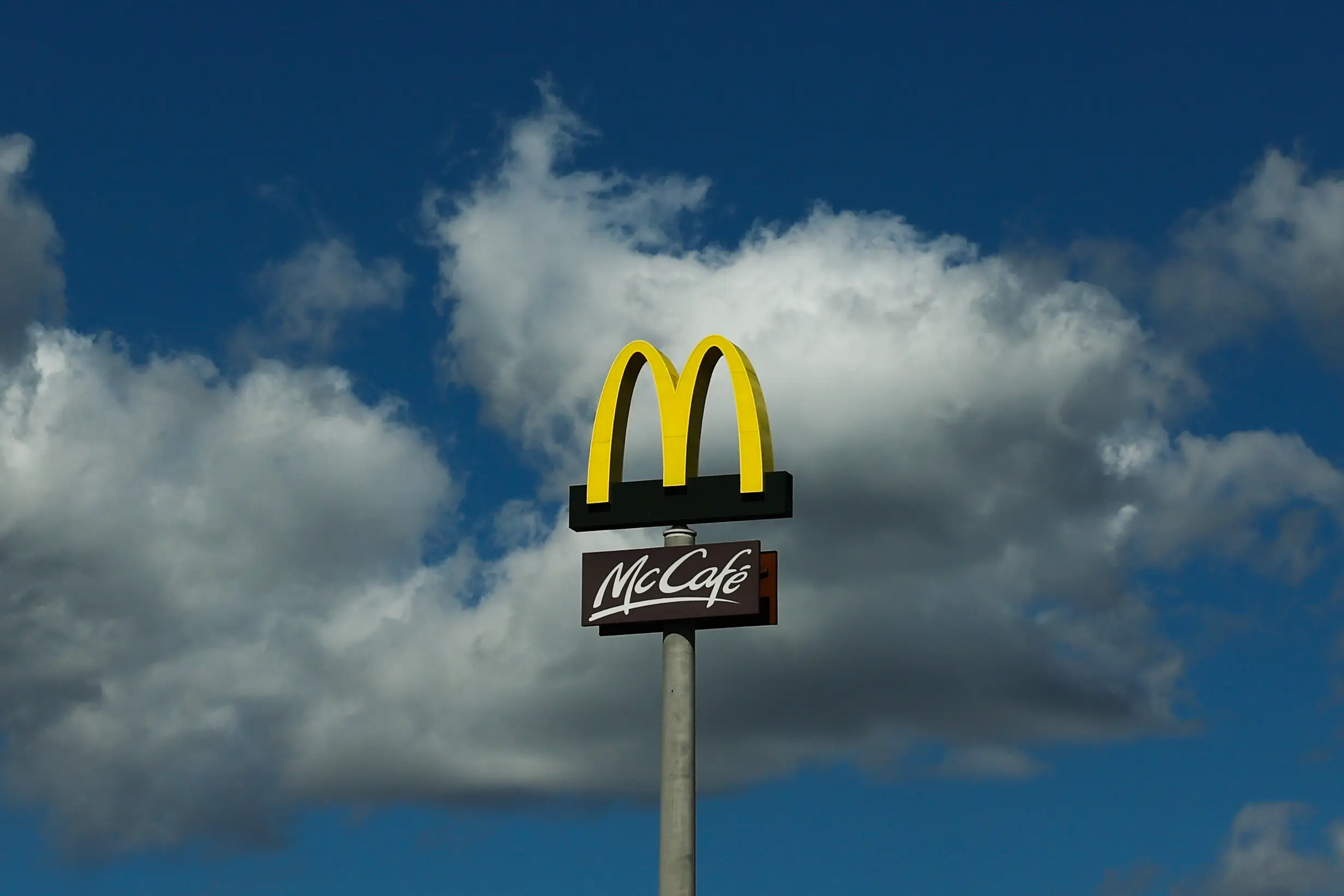 A McDonald's sign against a partly cloudy sky