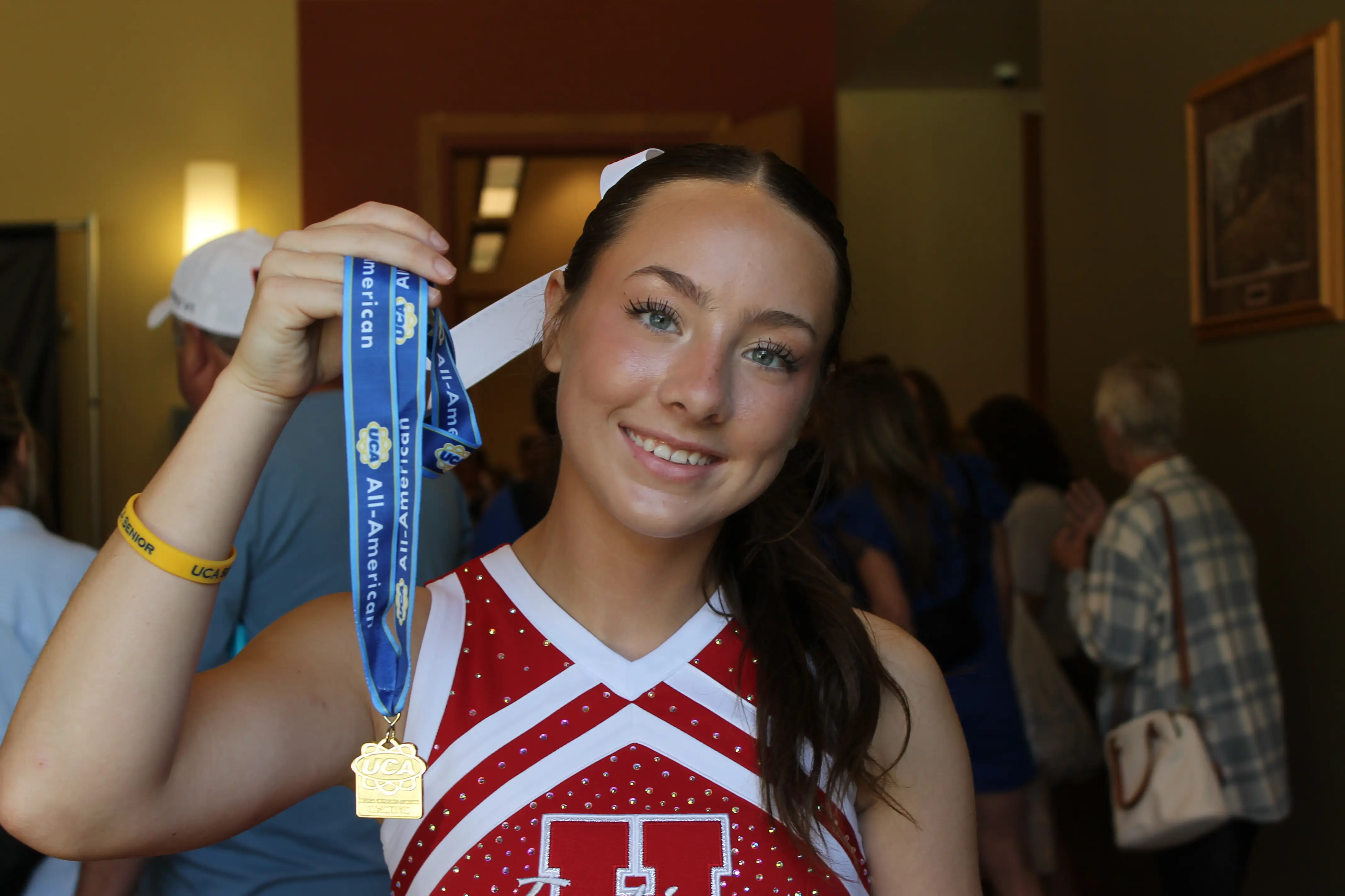 The author's daughter holds a medal won at a cheer competition.