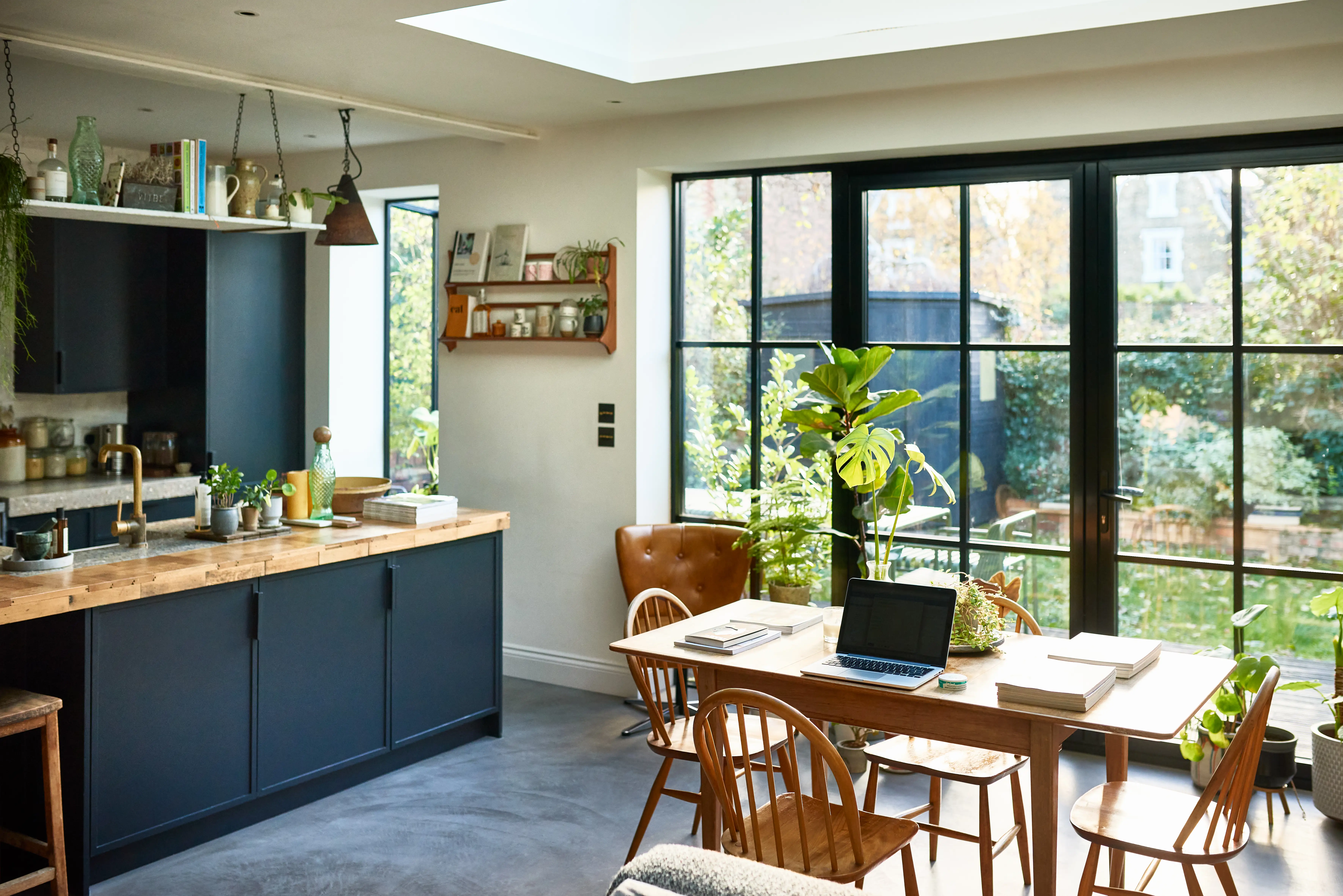 Kitchen with wood table, navy cabinets, large glass sliding doots