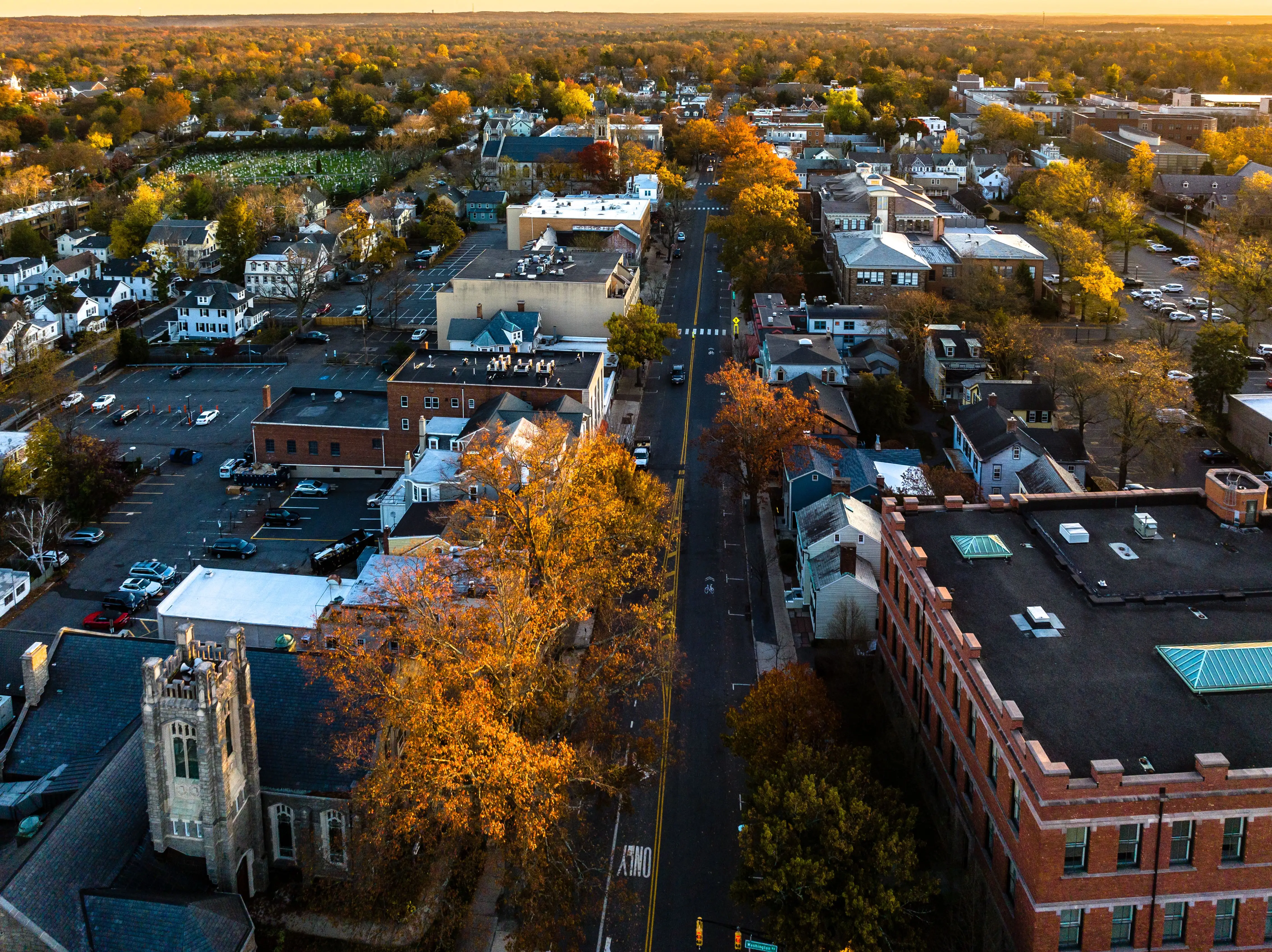 A drone view of golden sunrise over Princeton New Jersey. Cityscape with famous landmarks, university, residential buildings and roads.