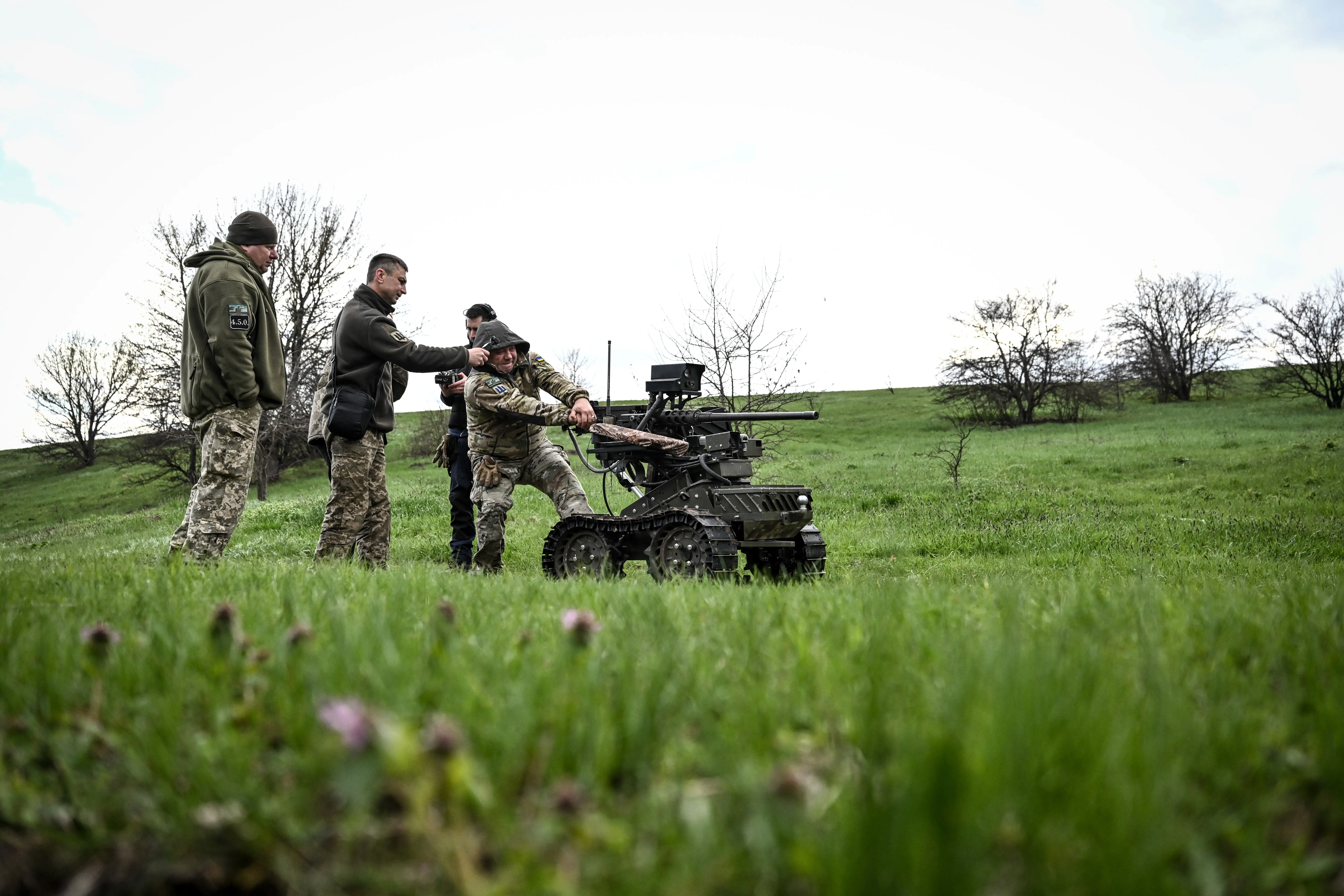 Soldiers stand by a ground robot during trials at a training ground on April 10, 2026.