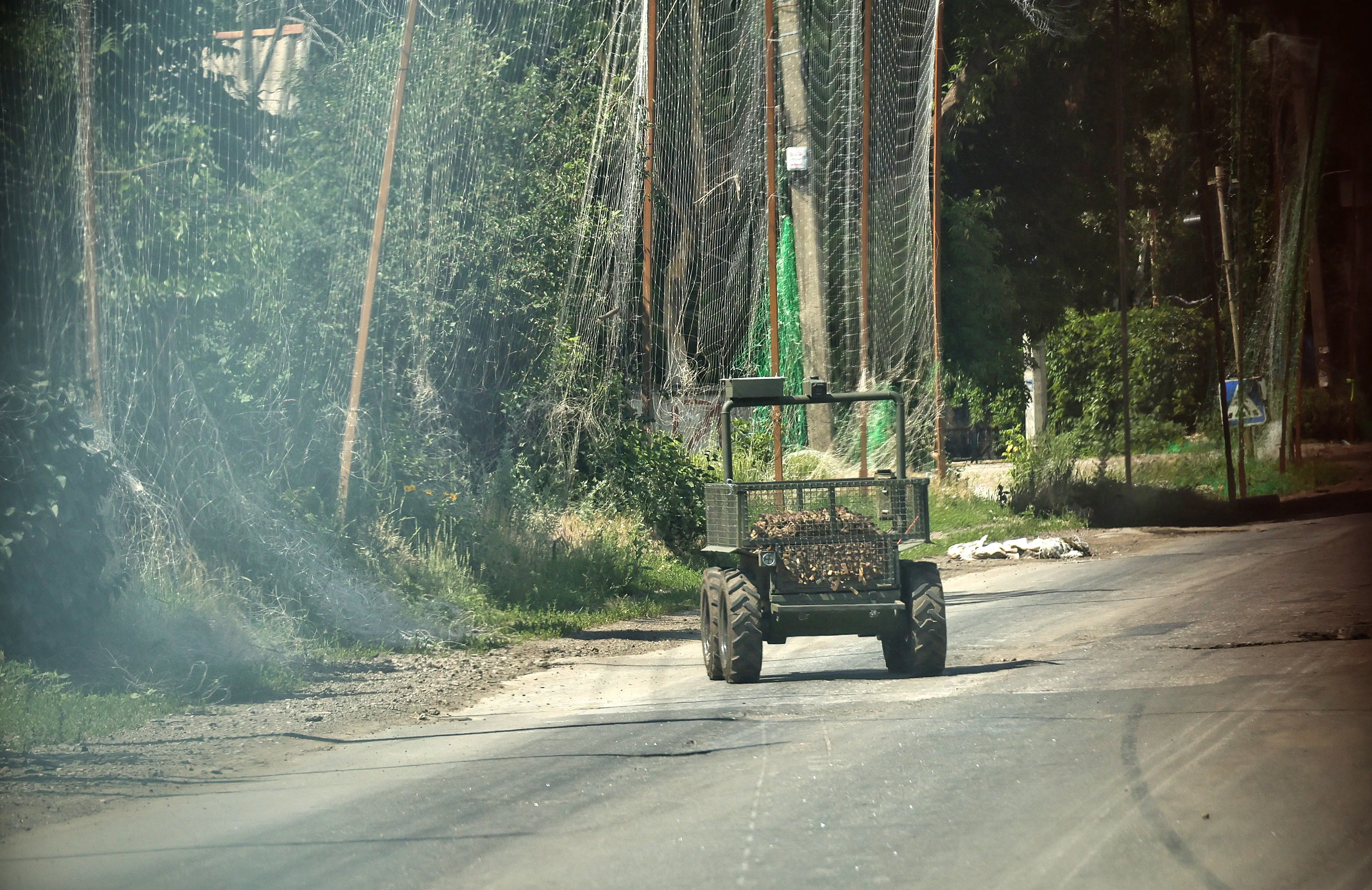 A ground robot operated by Ukrainian troops travels along a road protected by anti-drone nets in Druzhkivka, Donetsk region, on June 19, 2026.