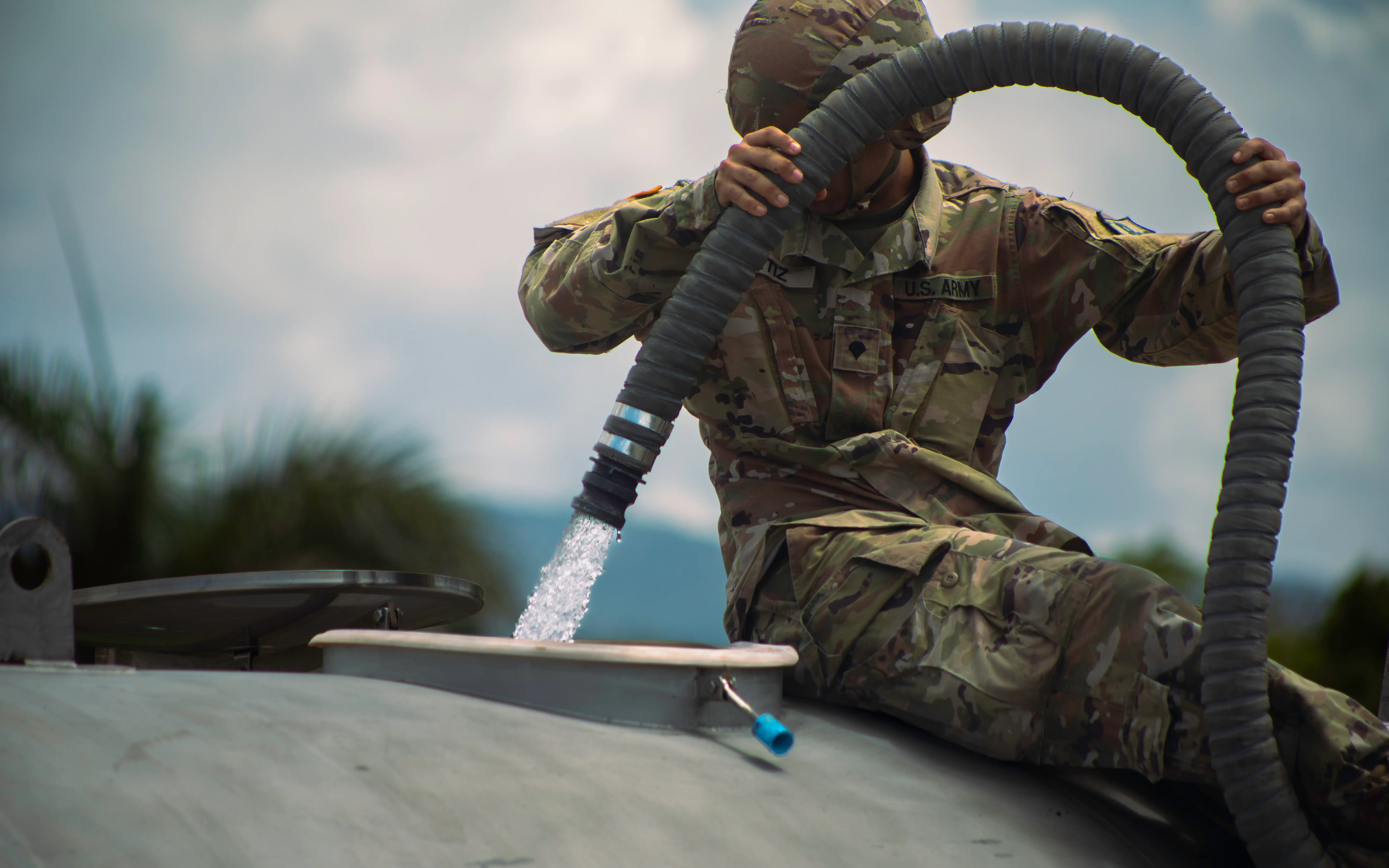 A US Army soldier fills up a portable water tank at Cidra, Puerto Rico, Aug. 18, 2024.