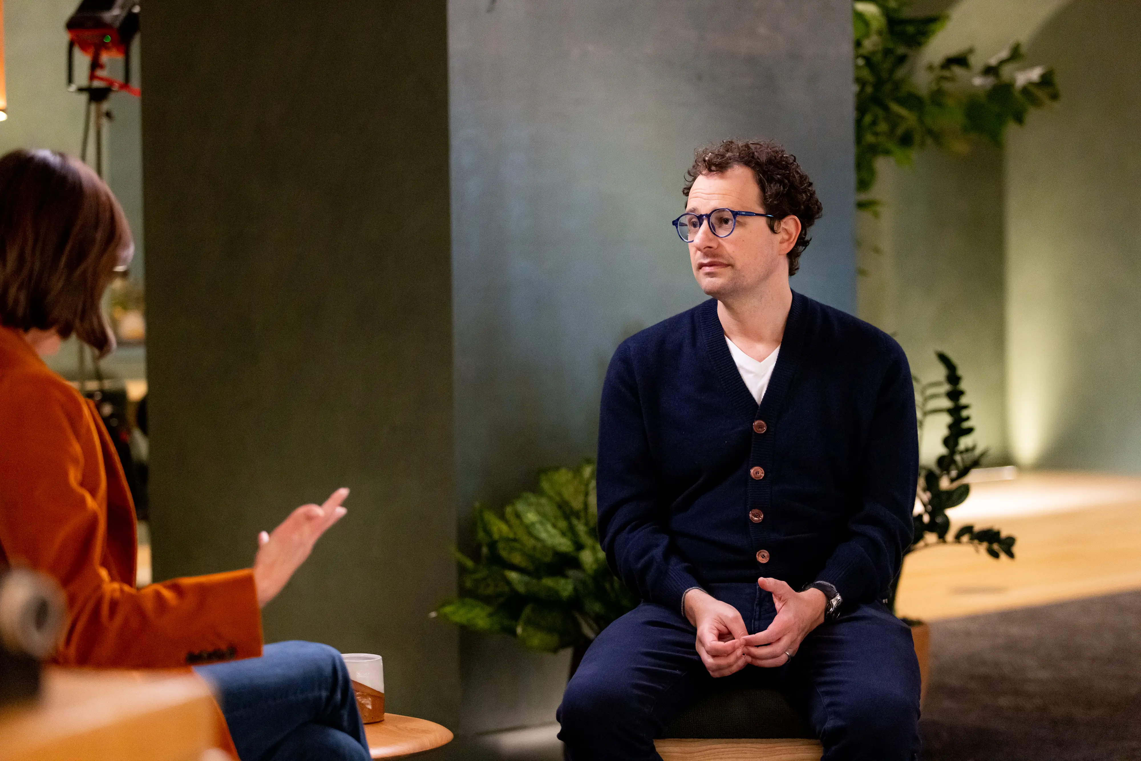 Anthropic CEO Dario Amodei sits in a chair during an interview.