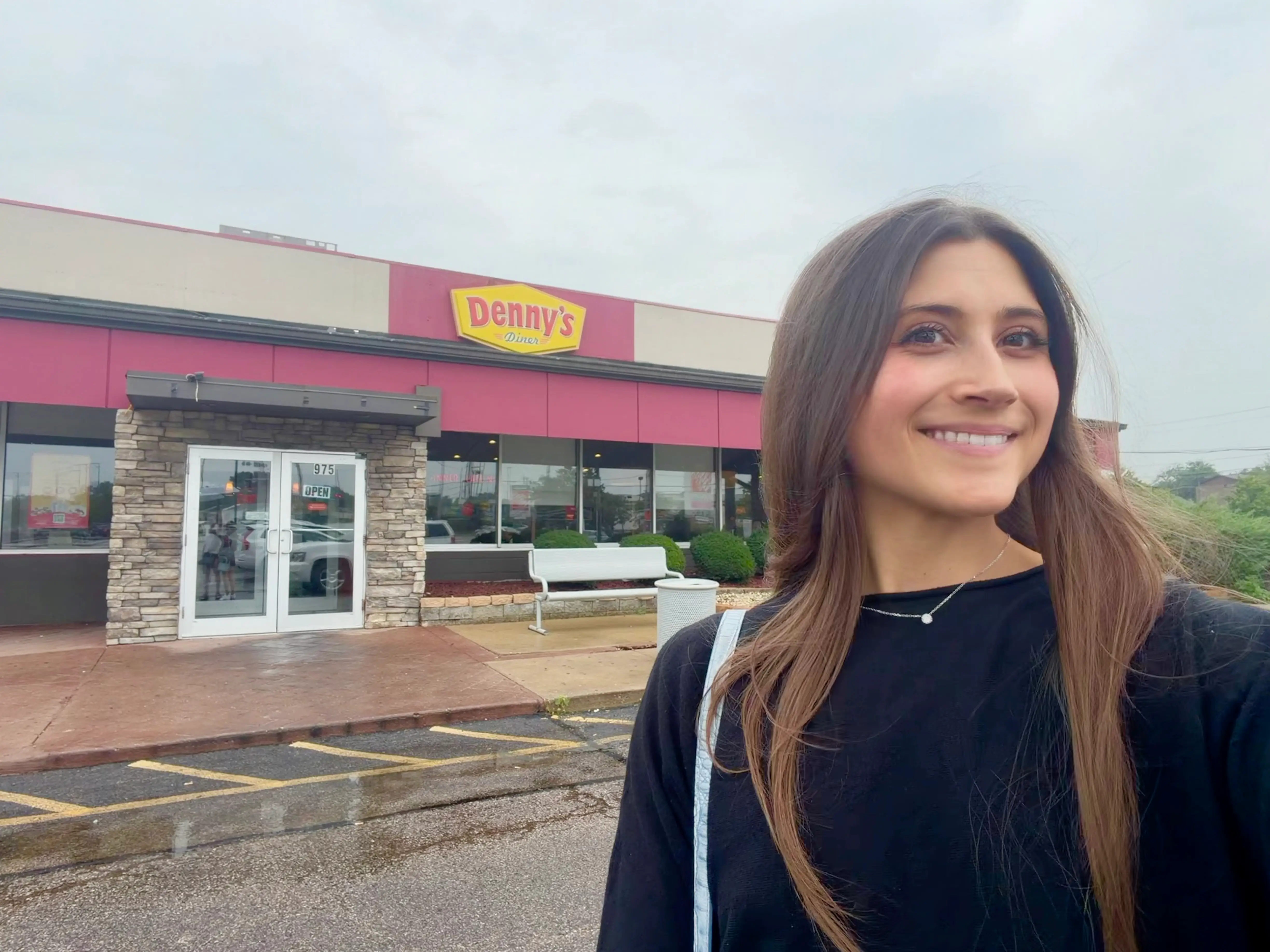 Woman smiling in front of a Denny's