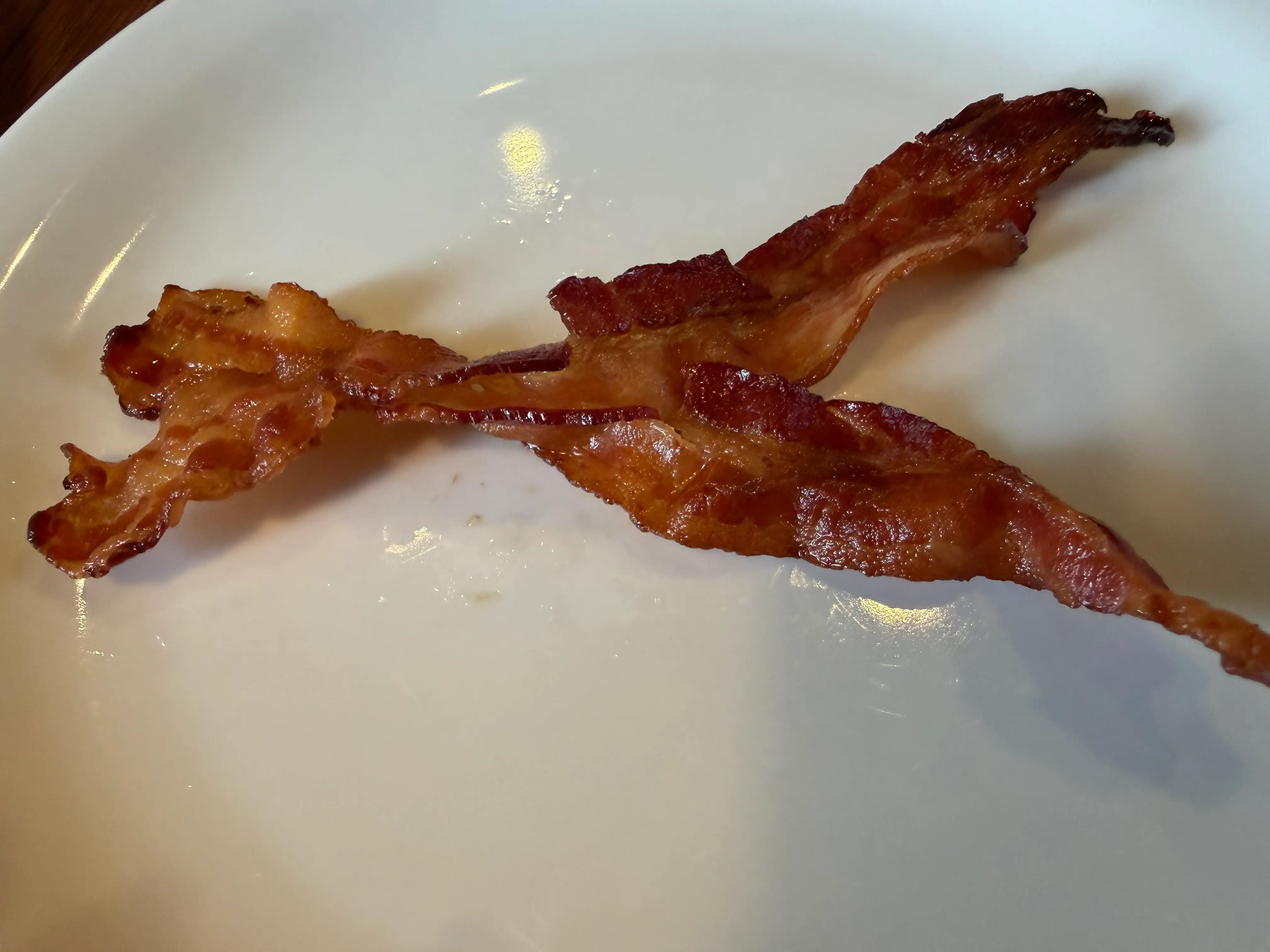Two piece of bacon on plate at Denny's