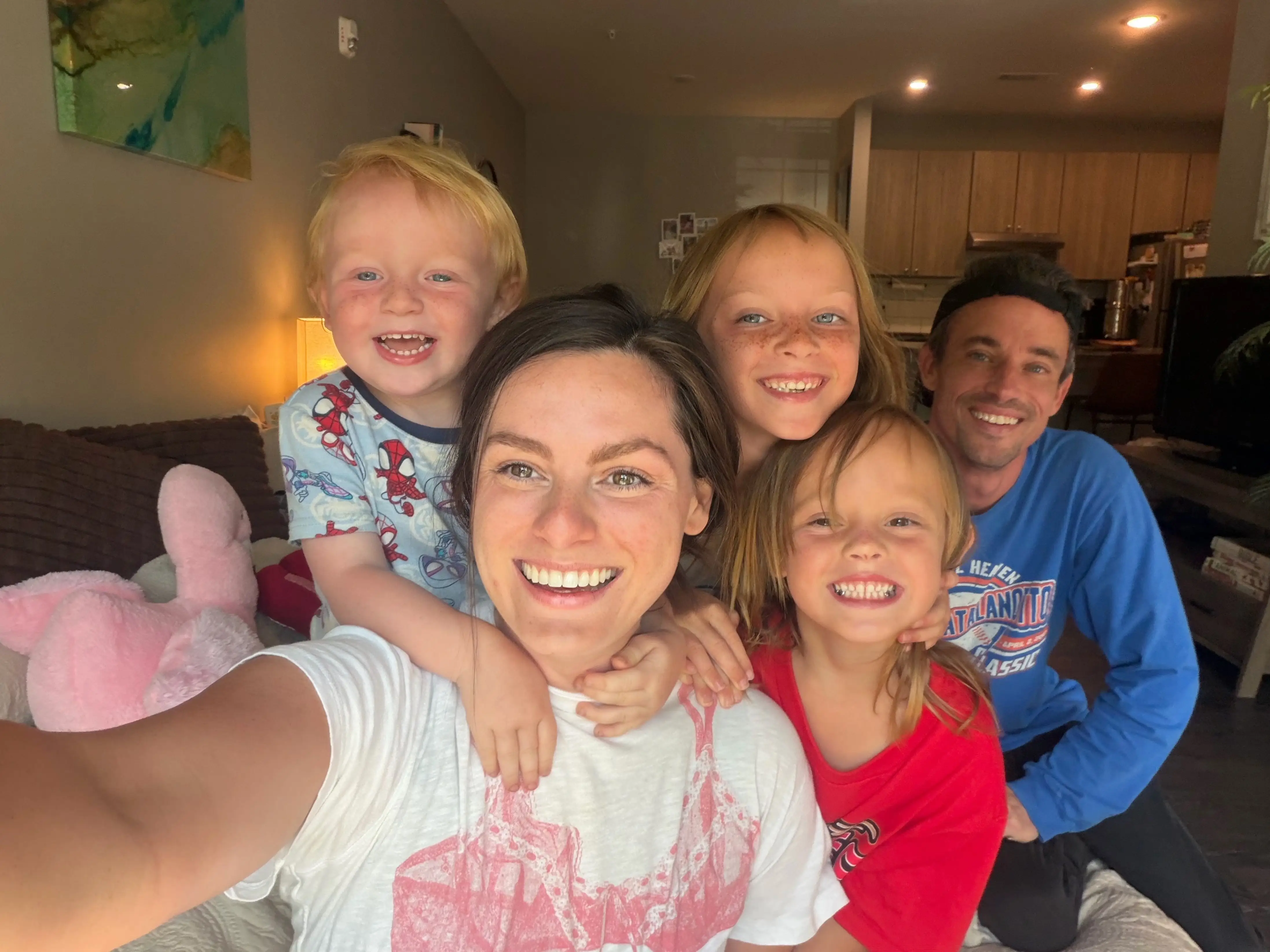 The writer, her husband, and her three kids pose for a selfie inside their apartment.