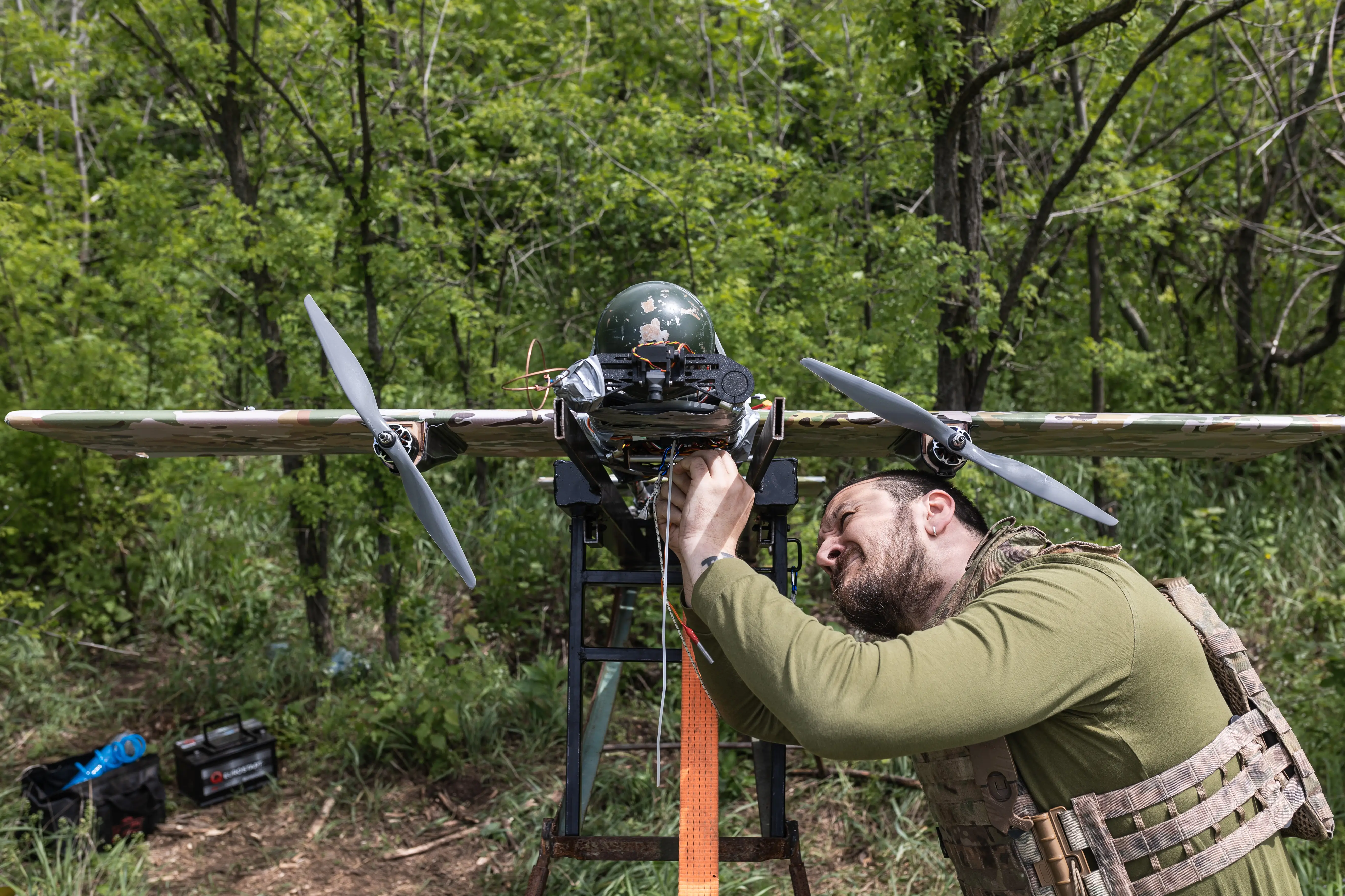 A Ukrainian soldier tinkers with a fixed wing attack drone.