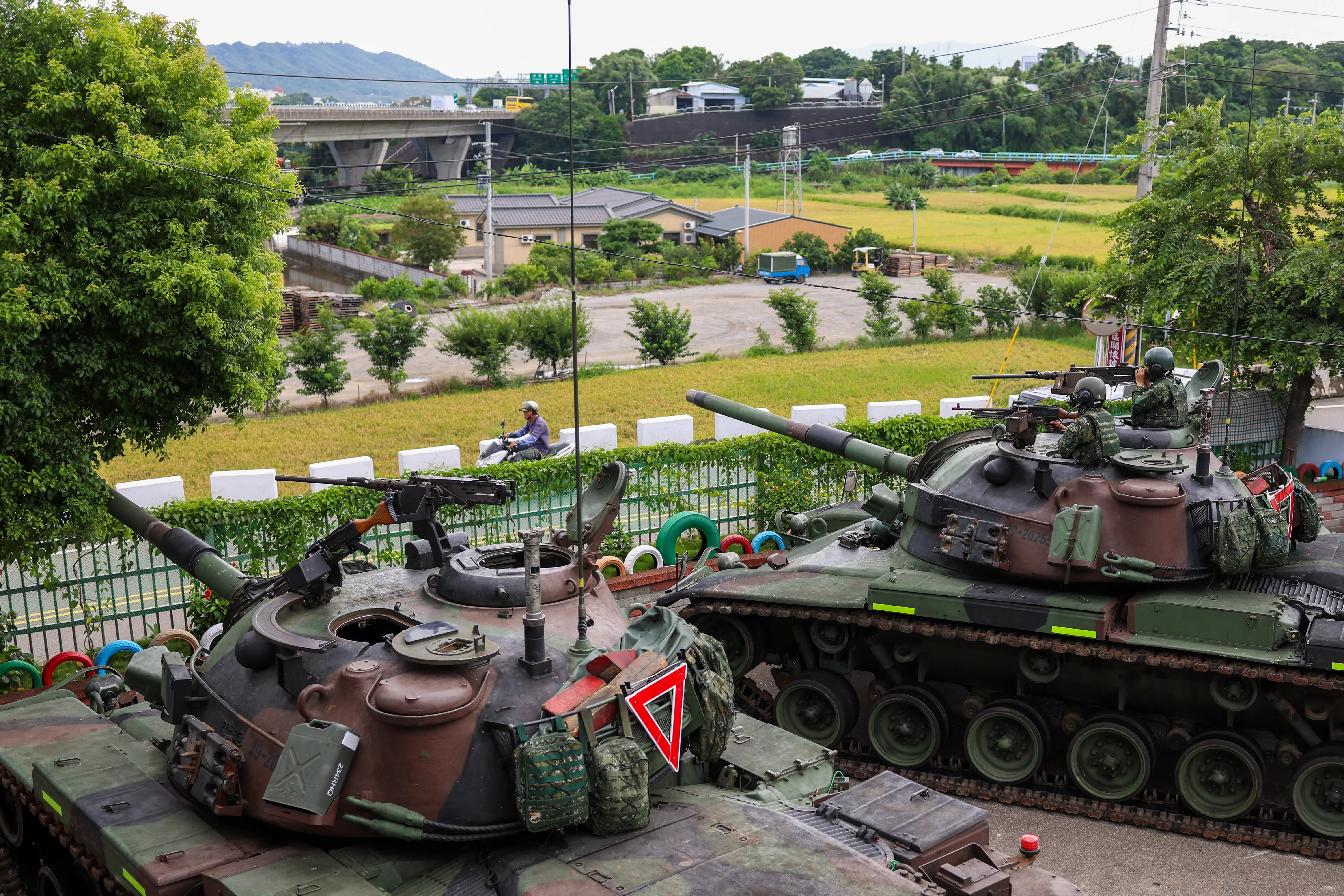 Two CM-11 Brave Tigers watch over a road.