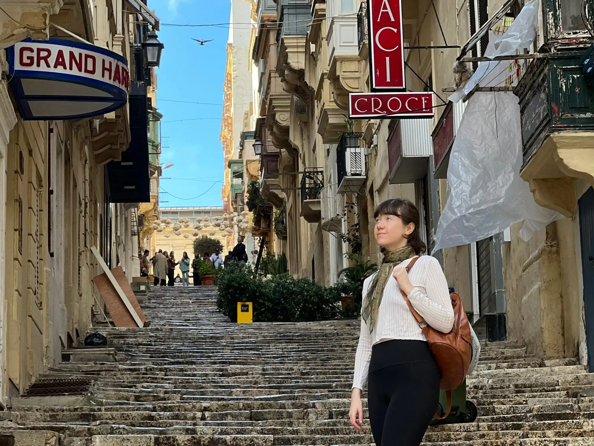 Anya stands on old steps in Malta.